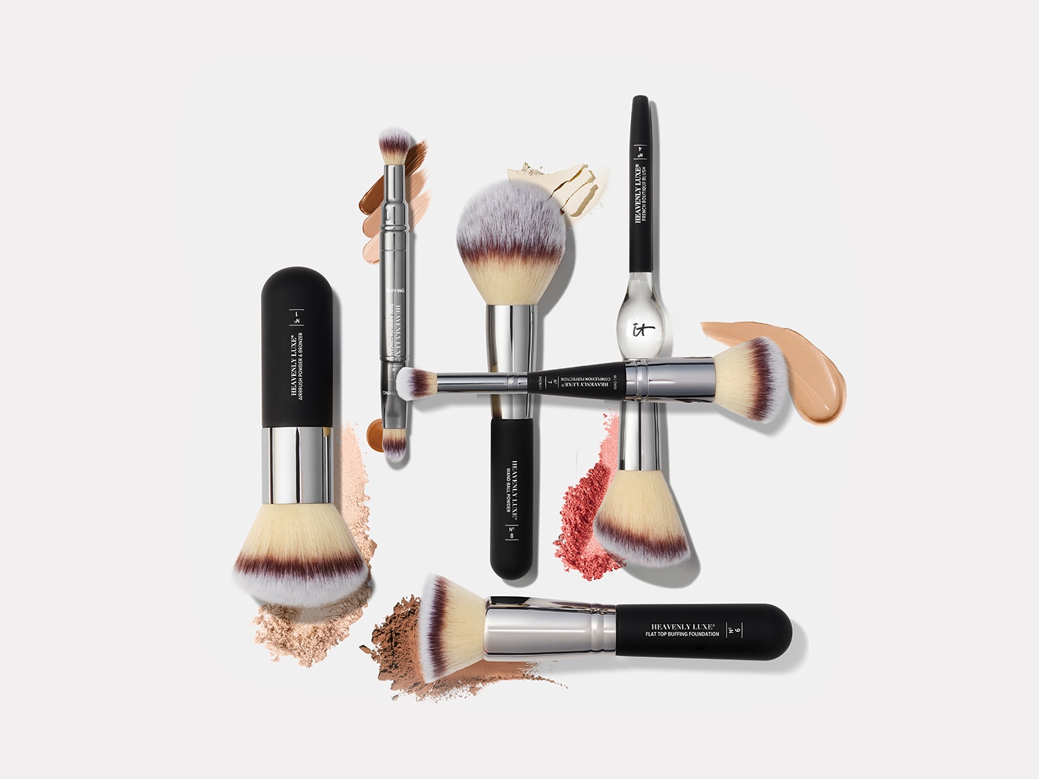 Különféle sminkecsetek láthatók, köztük púder-, pirosító- és alapozóecsetek, amelyek fekete nyéllel és ezüstös fémrészekkel rendelkeznek, a szőrszálak pedig fehérből barnába mennek át.