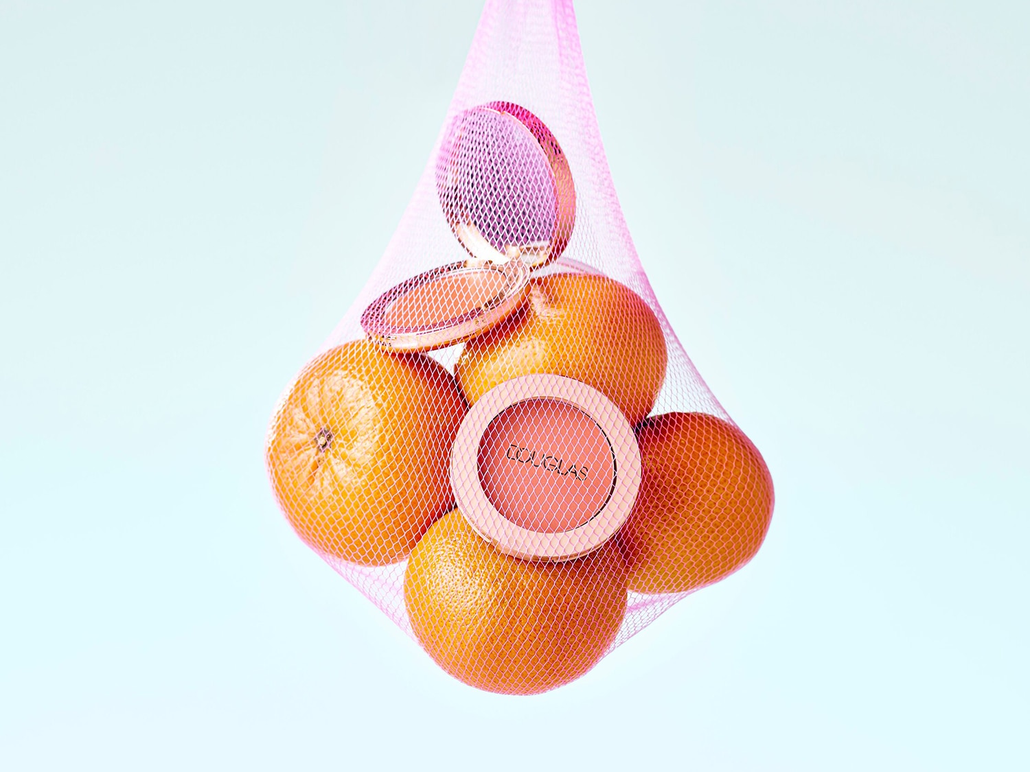 Pomarańcze i róż w różowej siatce: puder do policzków Douglas w odcieniach pomarańczy, idealny do podkreślenia naturalnego blasku.