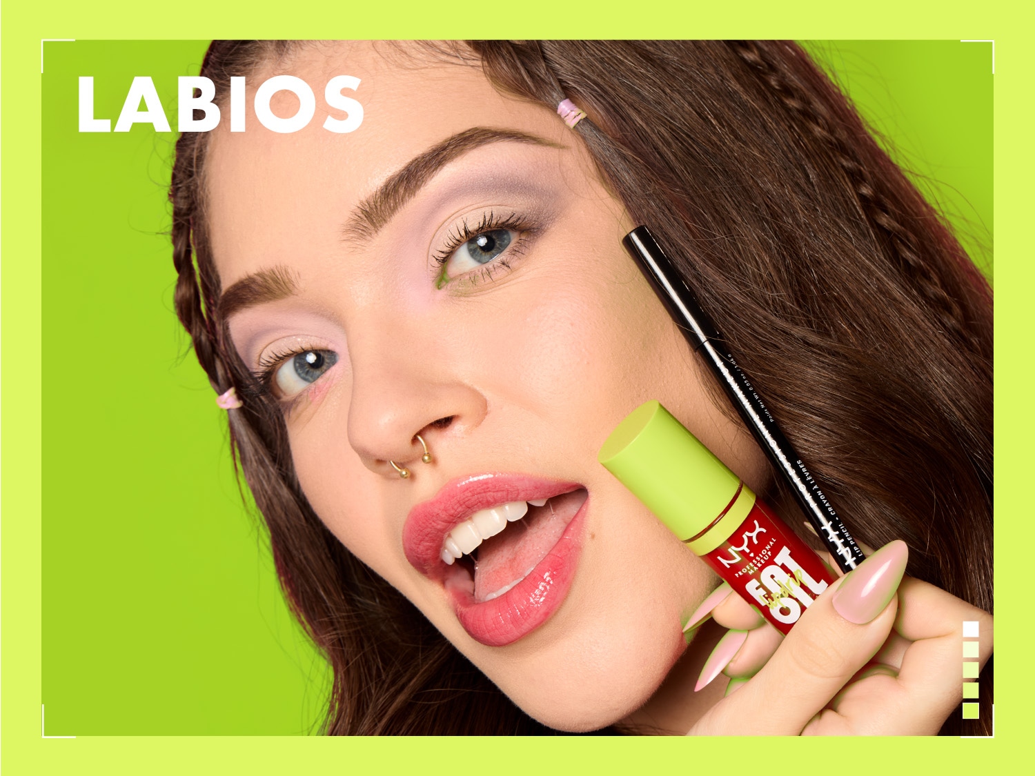 Una mujer sostiene un brillo labial rojo NYX Fat Oil con tapa verde lima y un delineador de labios negro, mostrando una sonrisa con labios brillantes y maquillaje de ojos colorido sobre un fondo verde.