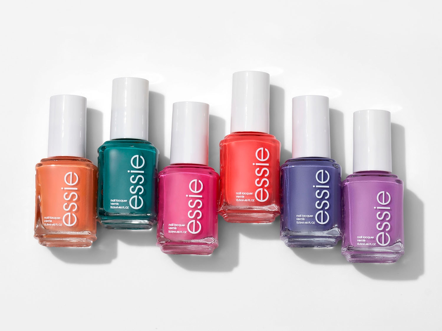 Aquí hay una colección de esmaltes de uñas Essie en varios tonos vibrantes, desde naranja y verde azulado hasta rosa, coral, azul y lavanda, perfectos para añadir un toque de color a tu estilo.