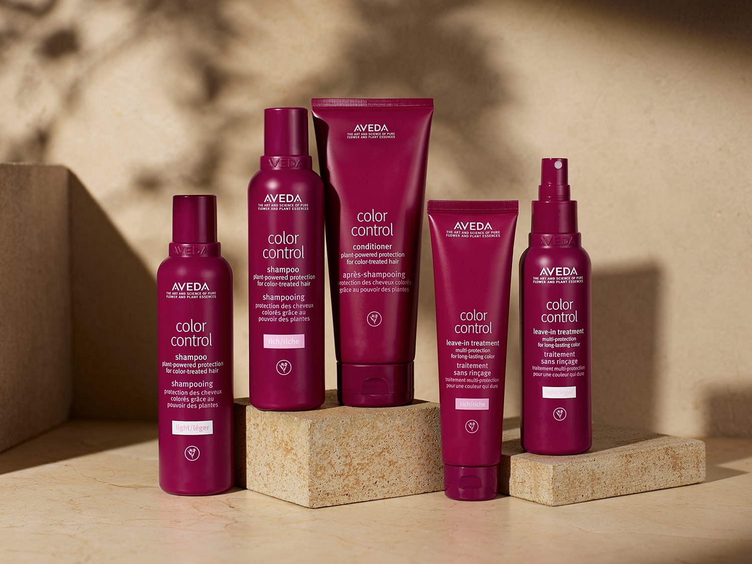 Eine Reihe von Aveda Color Control Produkten in violetten Verpackungen, darunter Shampoos, Conditioner und Leave-in-Treatments für coloriertes Haar.