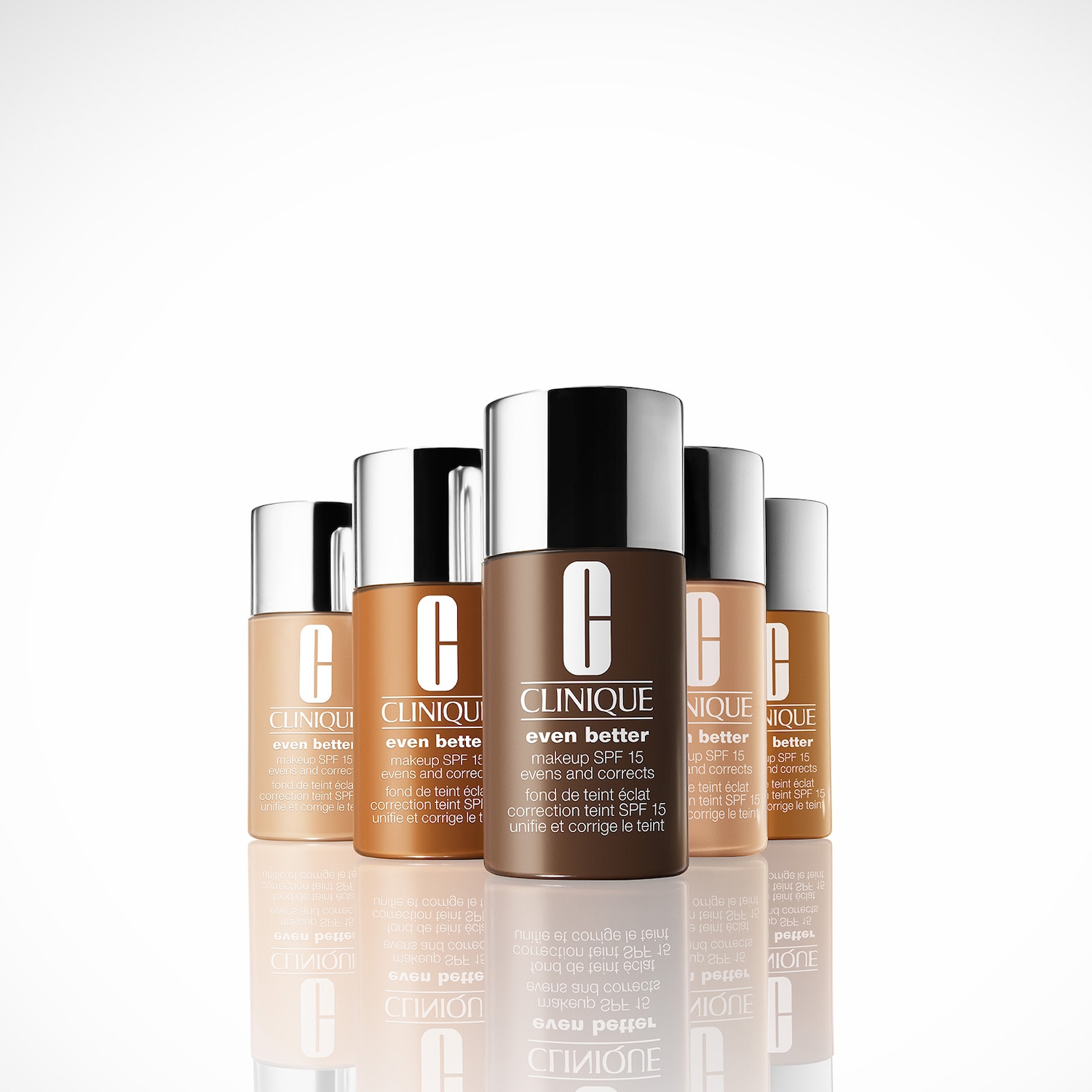 Eine Reihe von Clinique Even Better Make-up-Flaschen in verschiedenen Hauttönen mit silbernen Kappen, die für einen ebenmäßigen Teint mit LSF 15 sorgen.