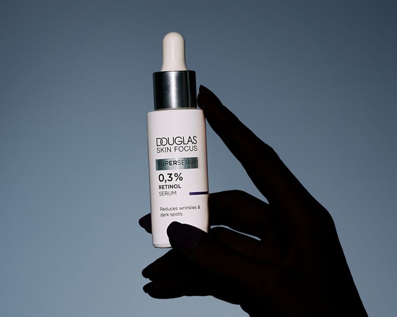 Découvrez le sérum rétinol 0,3% Skin Focus de Douglas, un soin anti-âge qui réduit les rides et les taches brunes, présenté dans un flacon blanc élégant avec pipette.