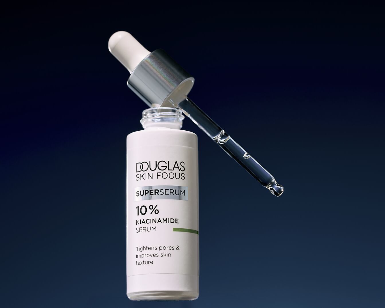 Le sérum niacinamide à 10 % DOUGLAS SKIN FOCUS SUPERSERUM dans un flacon blanc avec un compte-gouttes argenté promet de resserrer les pores et d'améliorer la texture de la peau.