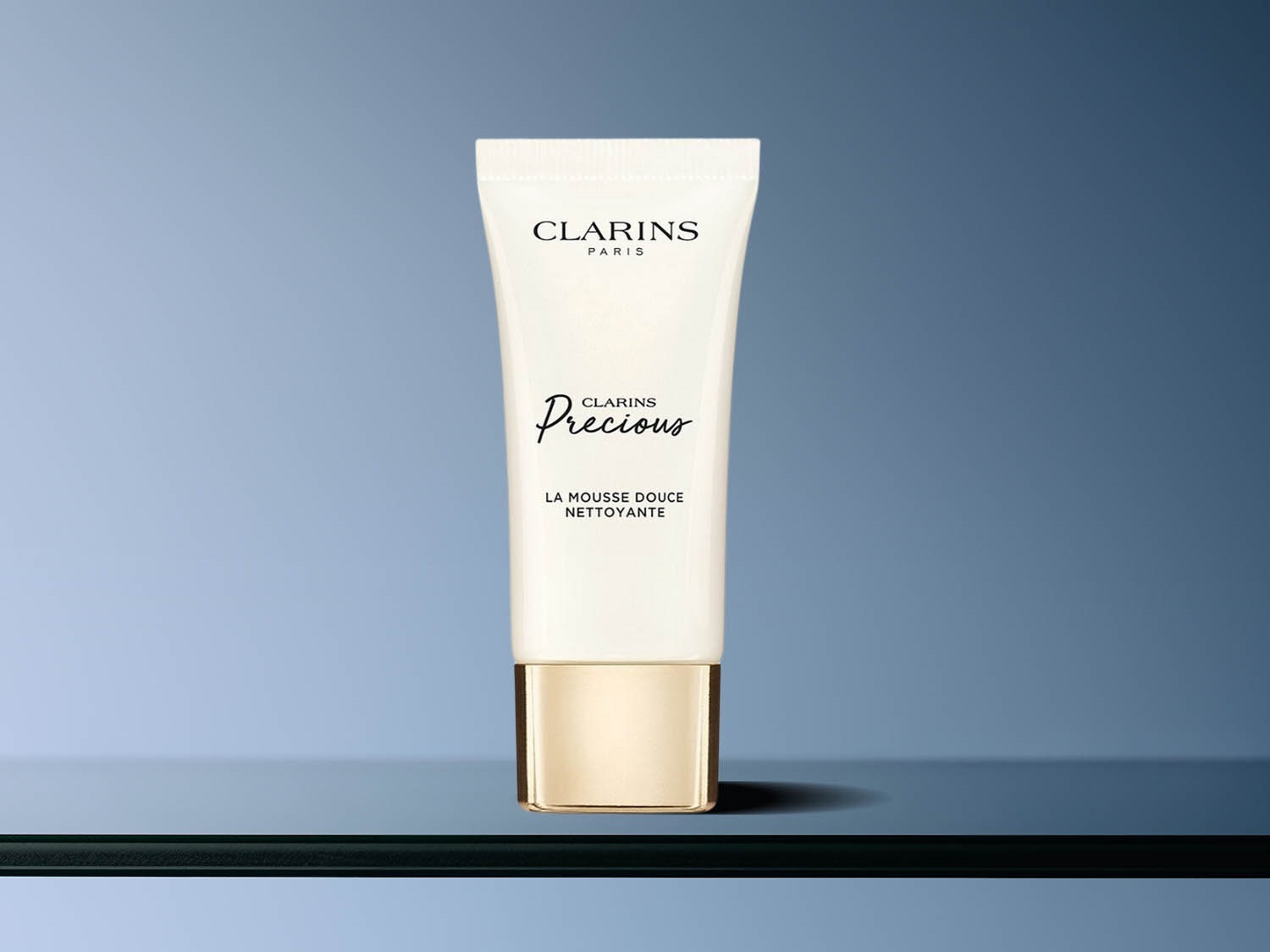 Biała tuba Clarins Precious La Mousse Douce Nettoyante z napisem w kolorze czarnym i złotą nakrętką.