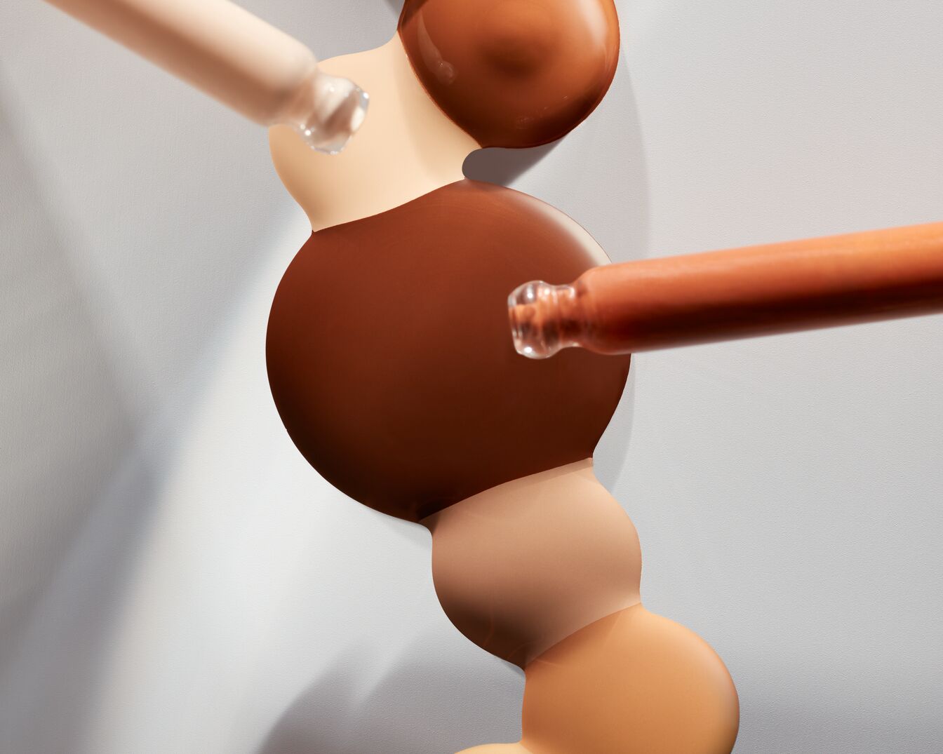 Šviesios ir tamsios spalvos pagrindo lašai iš buteliukų su pipetėmis ant baltos spalvos.