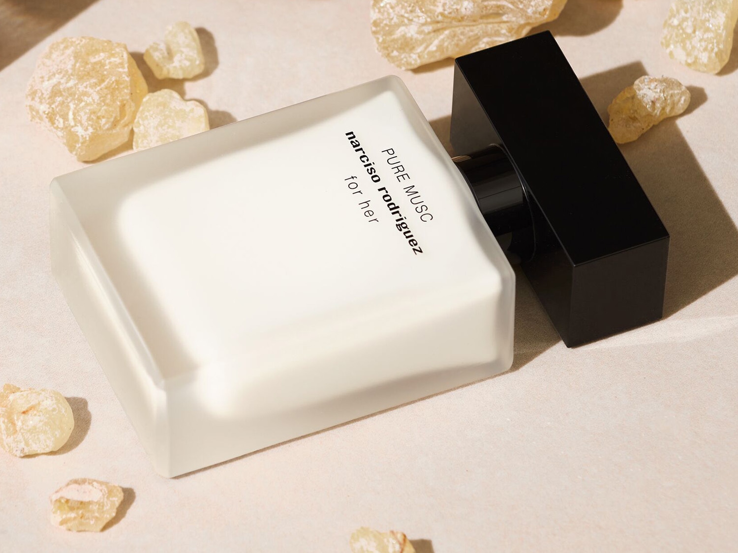 El frasco de perfume Pure Musc for Her de Narciso Rodriguez, con su diseño minimalista en blanco y negro, evoca una sensación de pureza y elegancia.