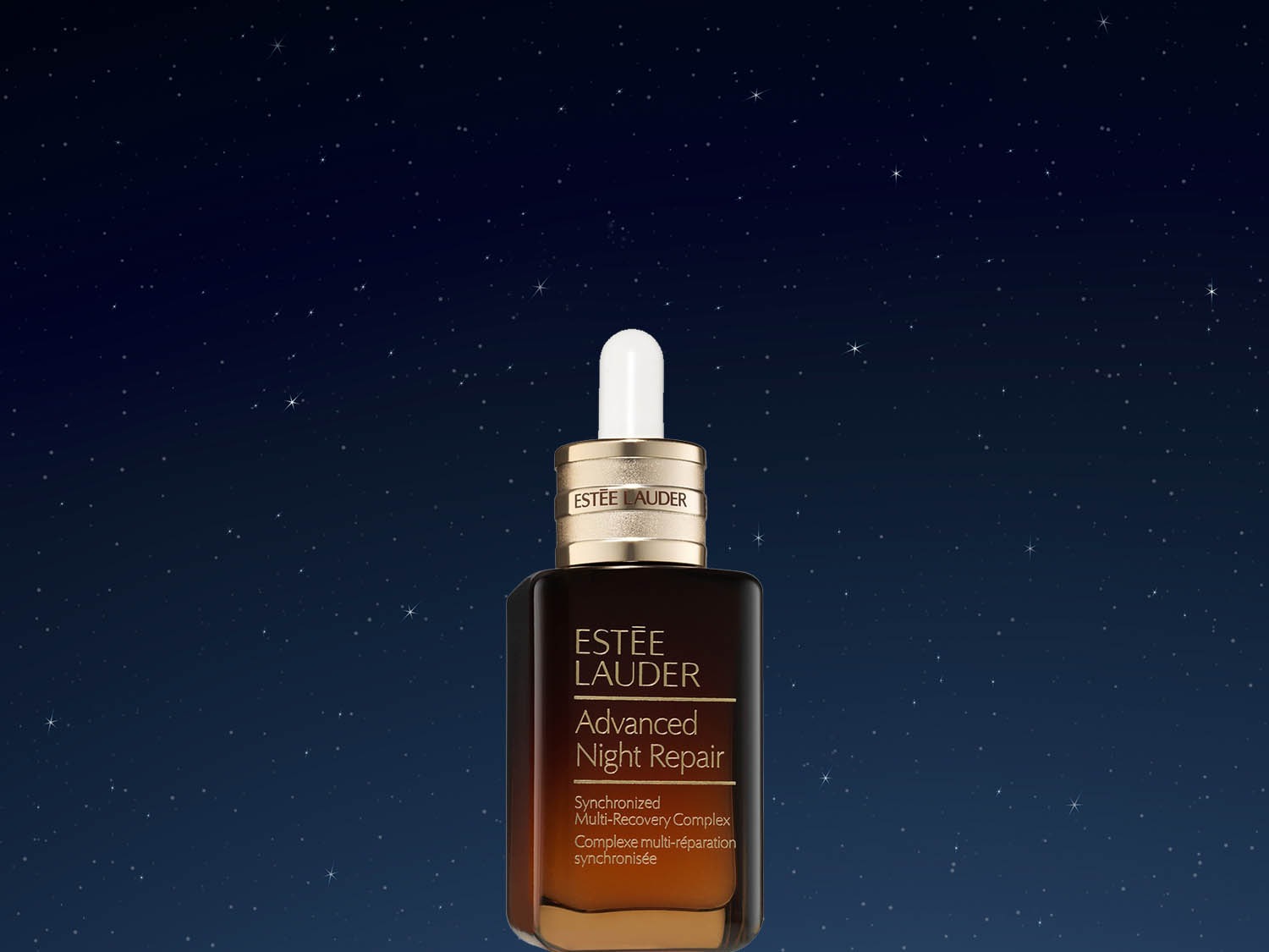 Butelka brązowego serum Estée Lauder Advanced Night Repair z pipetą na tle nocnego nieba.