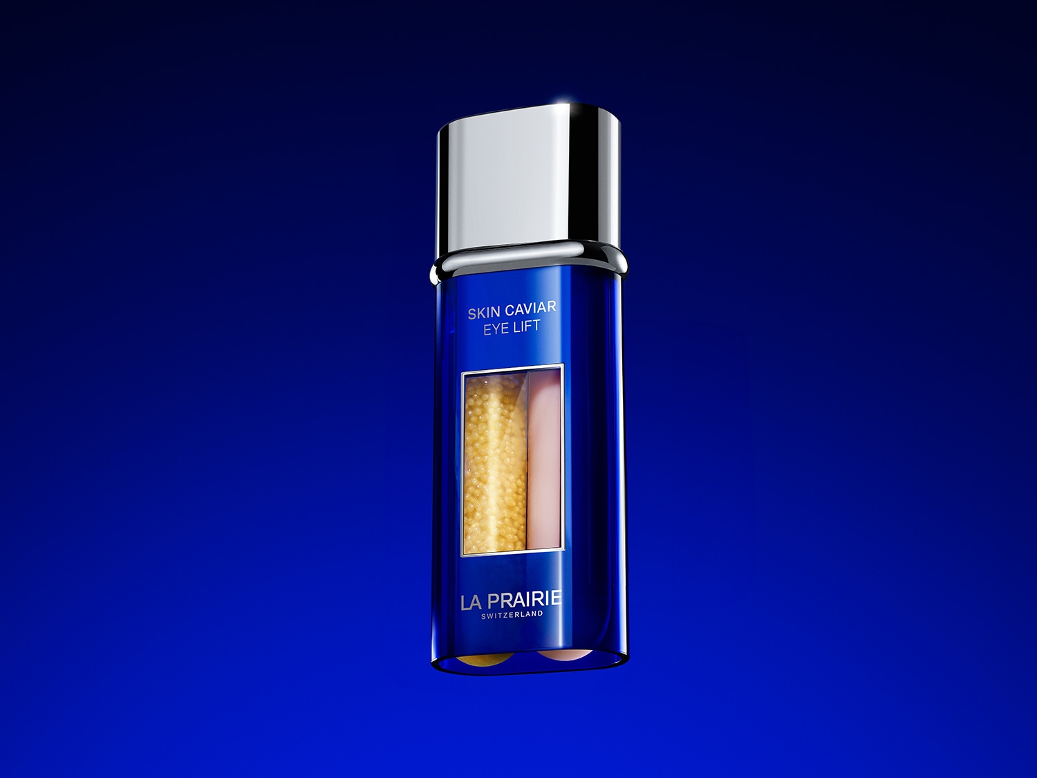Blaue La Prairie Skin Caviar Eye Lift Flasche mit silbernem Deckel und transparentem Fenster, das goldene Kügelchen und eine cremefarbene Flüssigkeit zeigt.