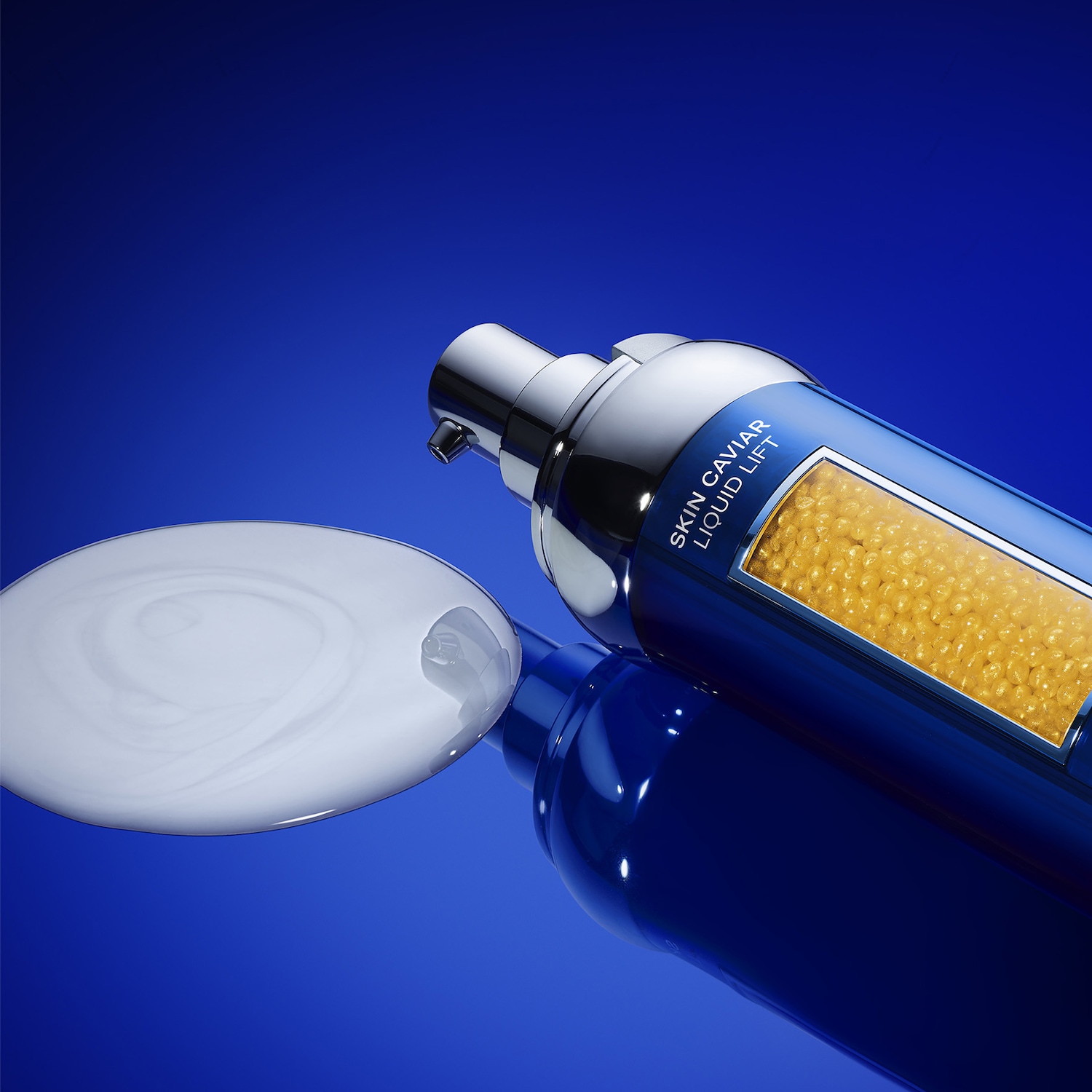 Nahaufnahme einer blauen Skin Caviar Liquid Lift Flasche mit silbernem Spender, daneben ein Klecks weißer Creme.