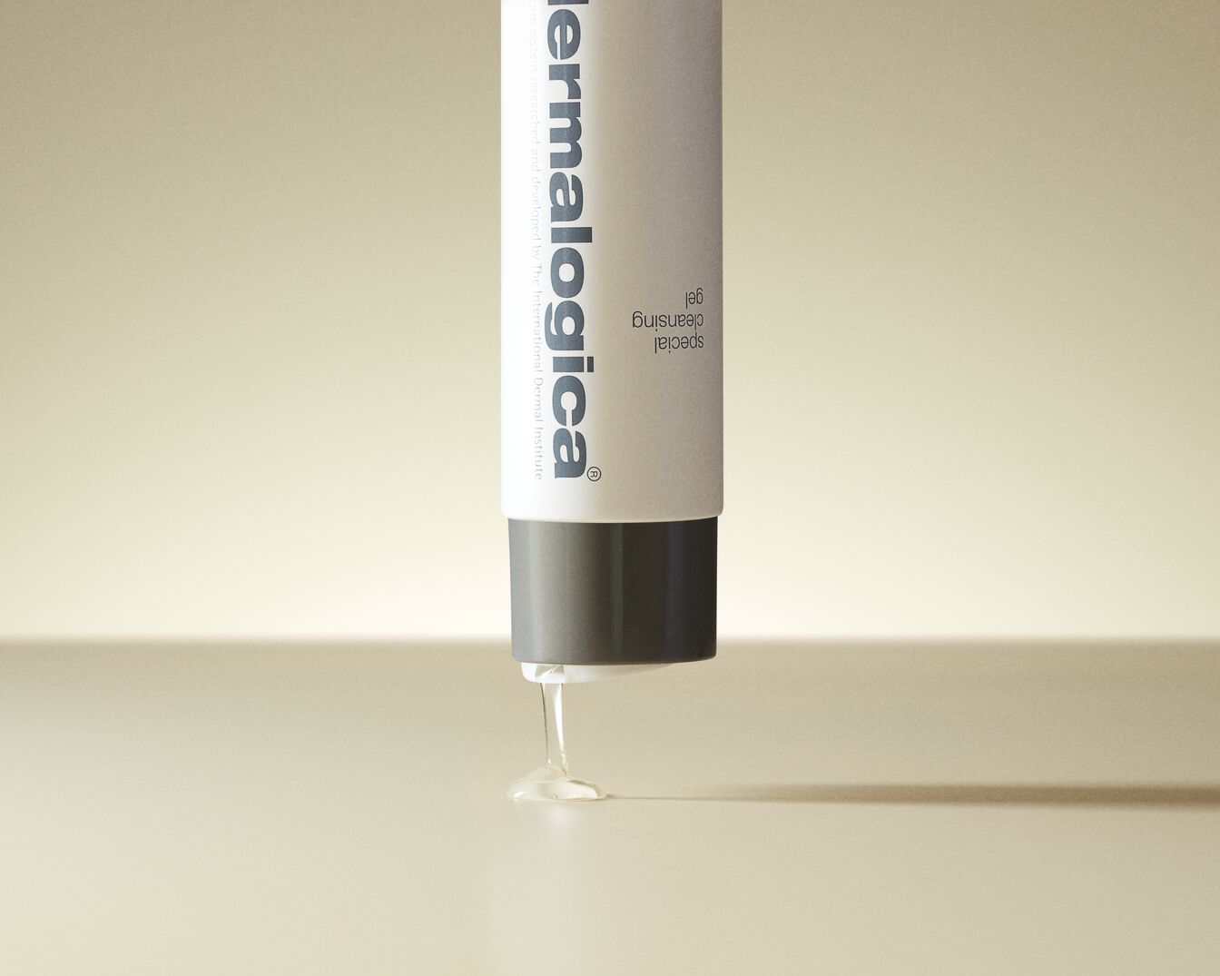 Eine Tube Dermalogica Special Cleansing Gel mit grauem Deckel, aus der ein Tropfen klares Gel austritt.