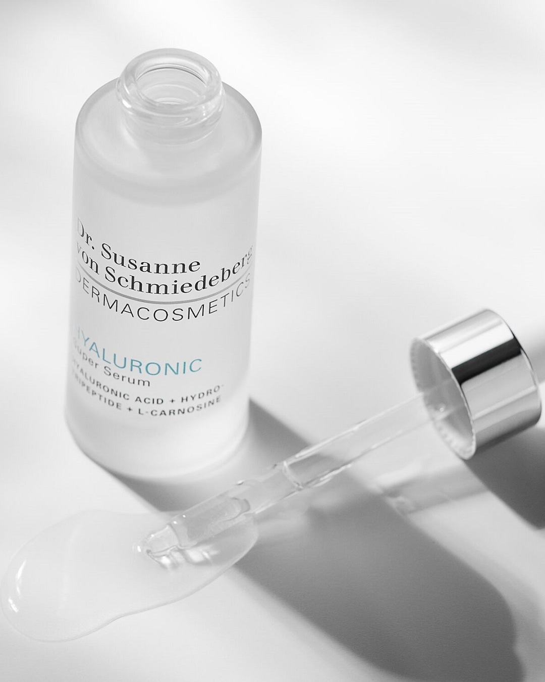 Das Hyaluronic Super Serum von Dr. Susanne von Schmiedeberg DERMACOSMETICS in einer durchsichtigen Glasflasche mit Pipette, die eine klare Flüssigkeit enthält.