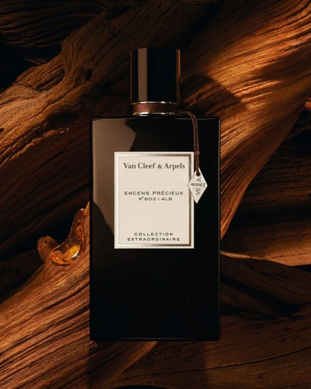 Découvrez le parfum Encens Précieux N°602 4LB de Van Cleef & Arpels, un parfum raffiné présenté dans un élégant flacon noir sur un fond de bois texturé.