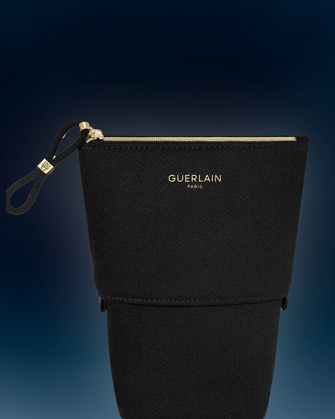 Czarna kosmetyczka Guerlain Paris z zamkiem błyskawicznym w kolorze złotym i uchwytem.