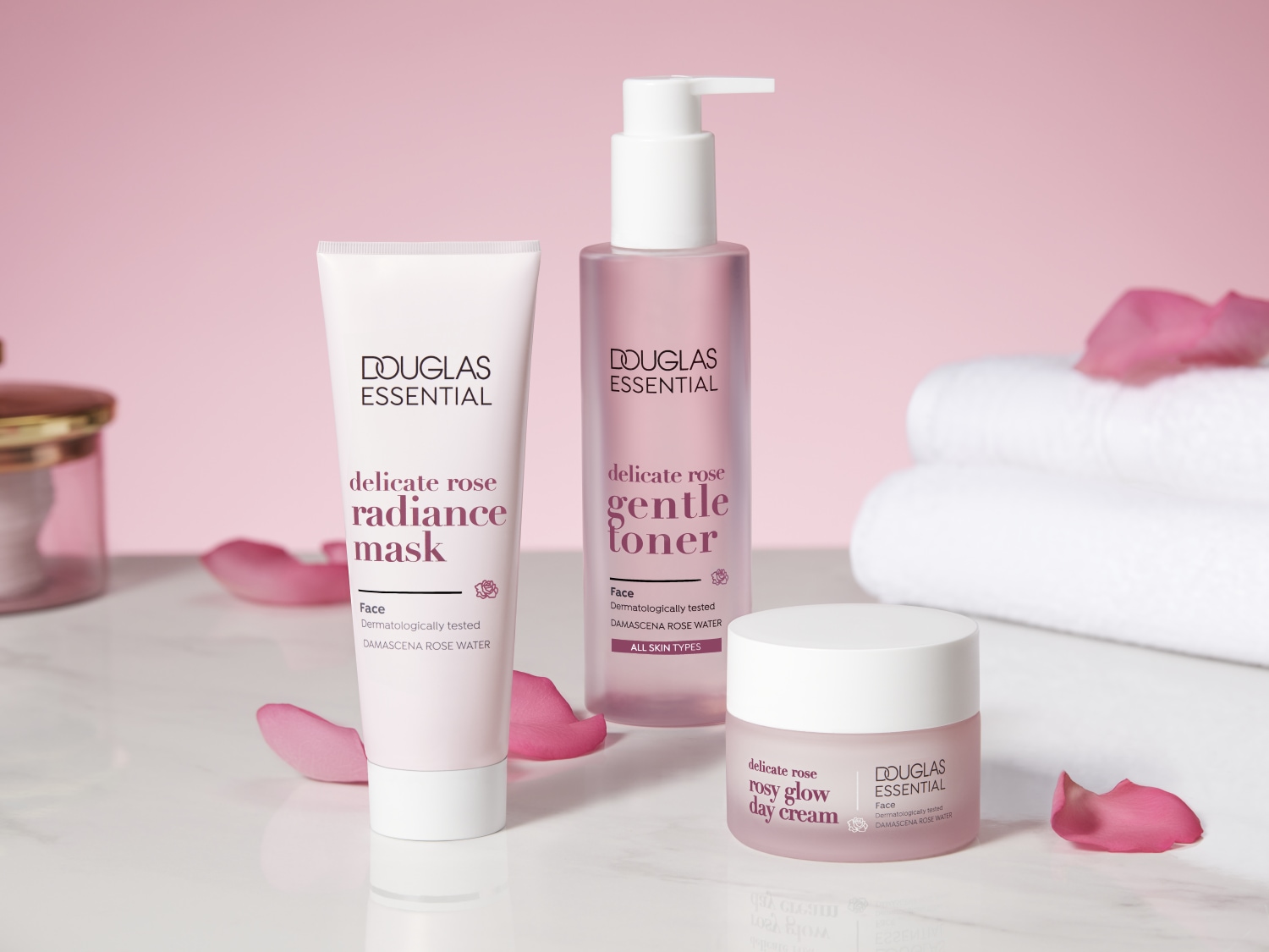 Švelnios rožės spindesio kaukė, tonikas ir dieninis kremas „Douglas Essential“ rinkinyje, skirtas veido priežiūrai su Damasko rožių vandeniu.