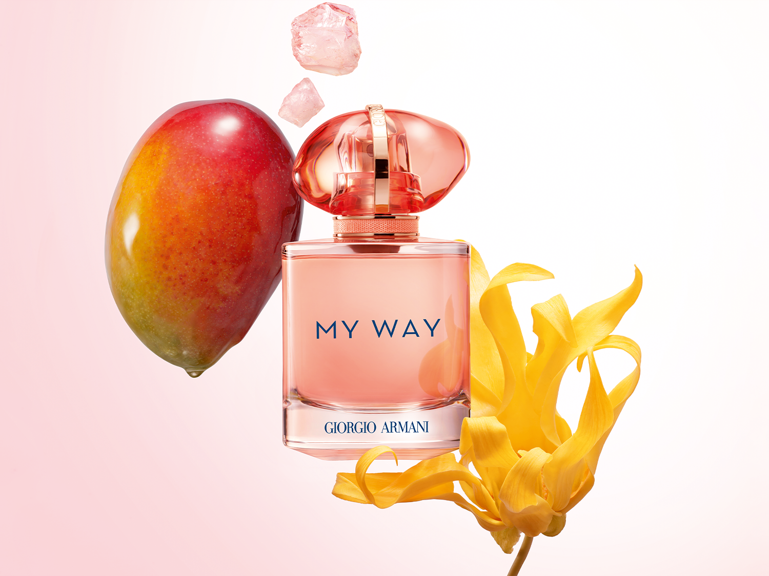 A Giorgio Armani My Way parfüm rózsaszín üvegben, mangóval, sárga virággal és rózsakvarc kristályokkal körülvéve.