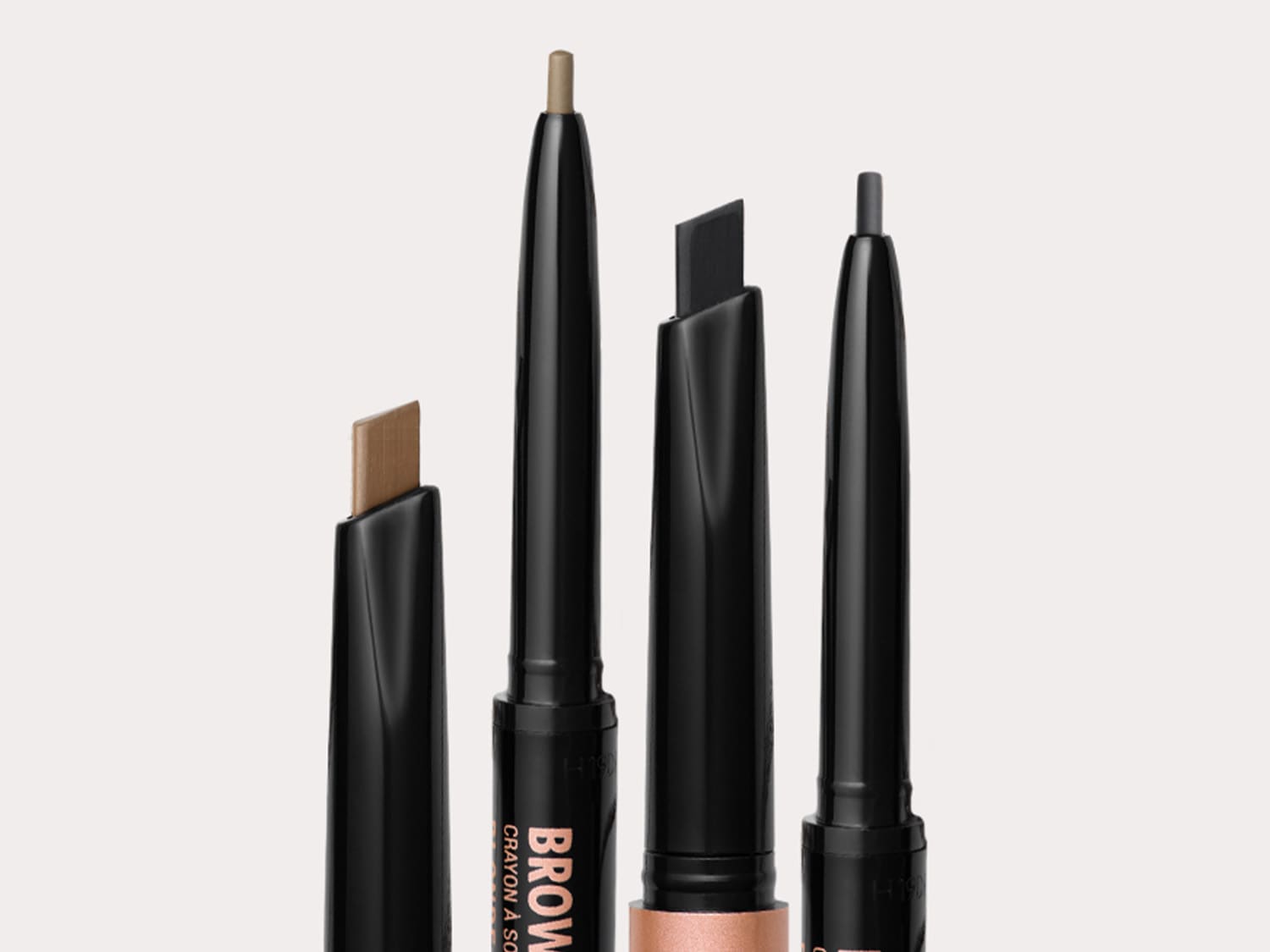 Négy szemöldökceruza látható különböző árnyalatokban, fekete csomagolásban, amelyekkel tökéletesítheted a szemöldöködet.