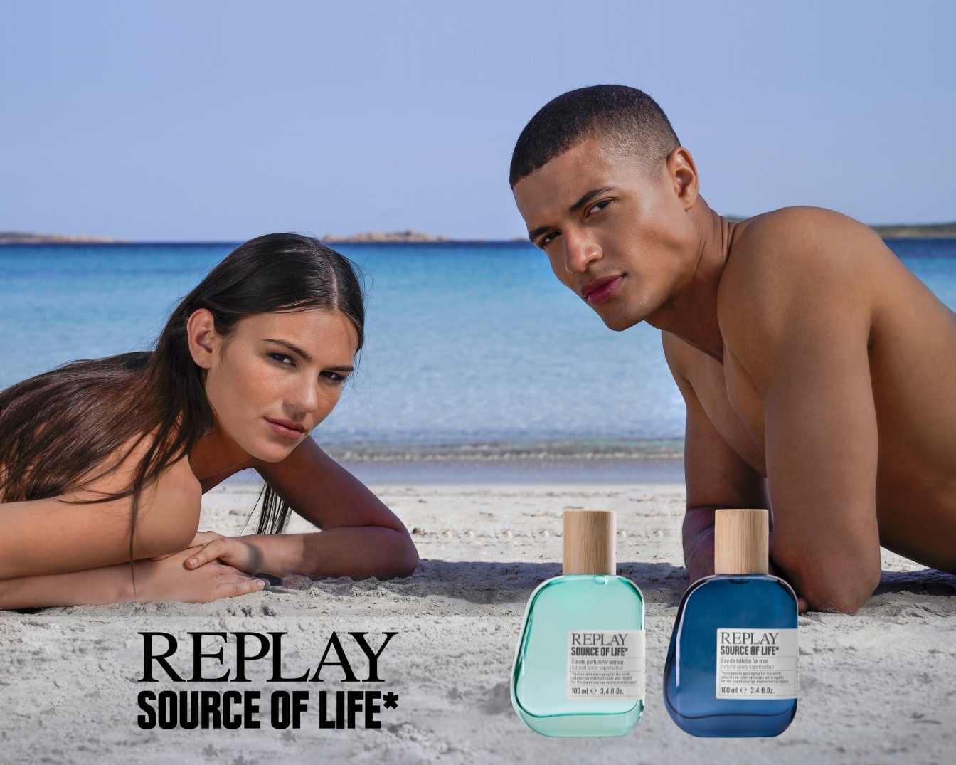 Sur la plage, un homme et une femme présentent les parfums Replay Source of Life dans des flacons bleu et turquoise.
