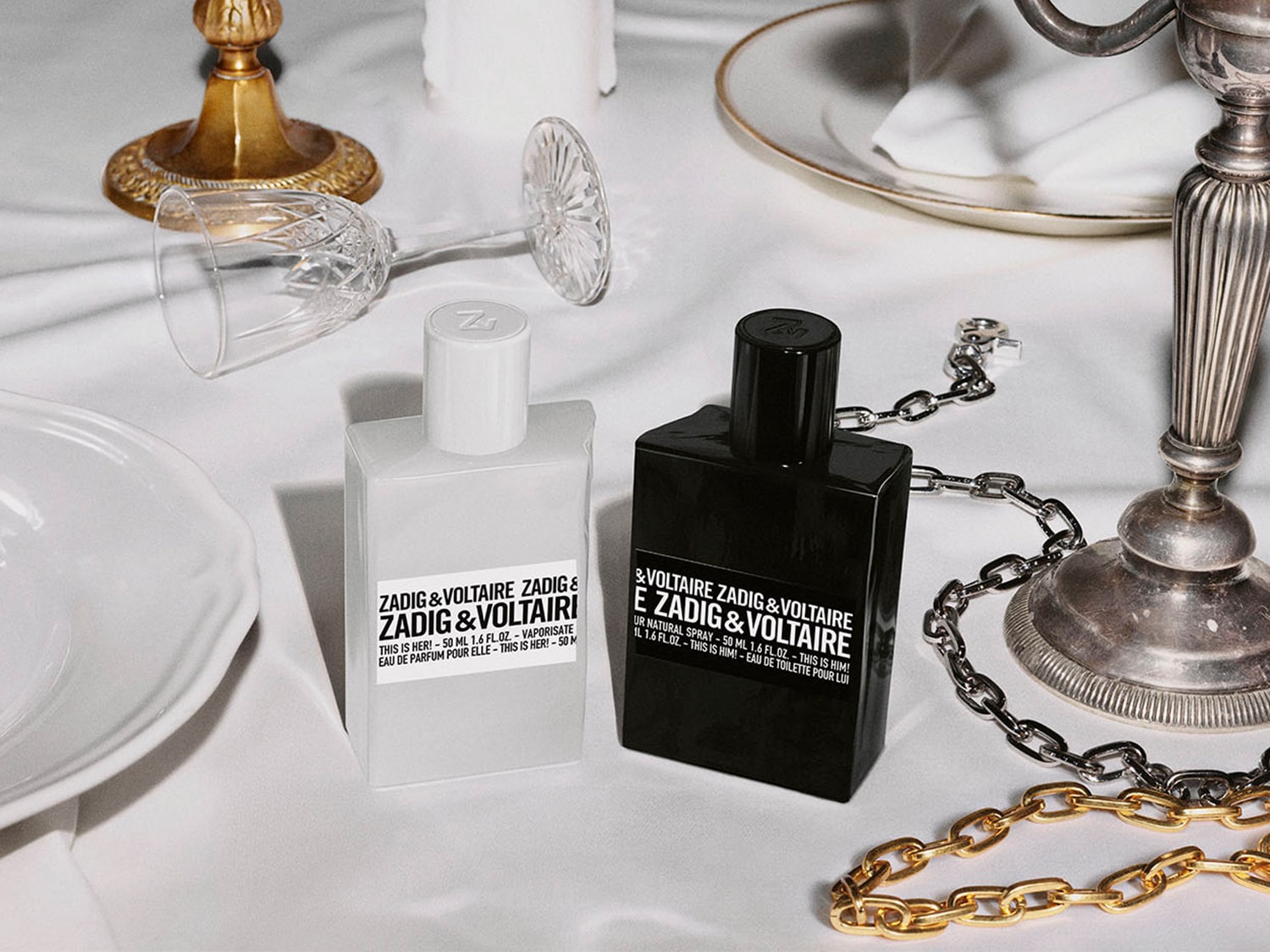 Zadig & Voltaire Parfums präsentiert zwei Flakons: einen weißen Duft für Sie und einen schwarzen Duft für Ihn, beide mit dem Schriftzug der Marke.