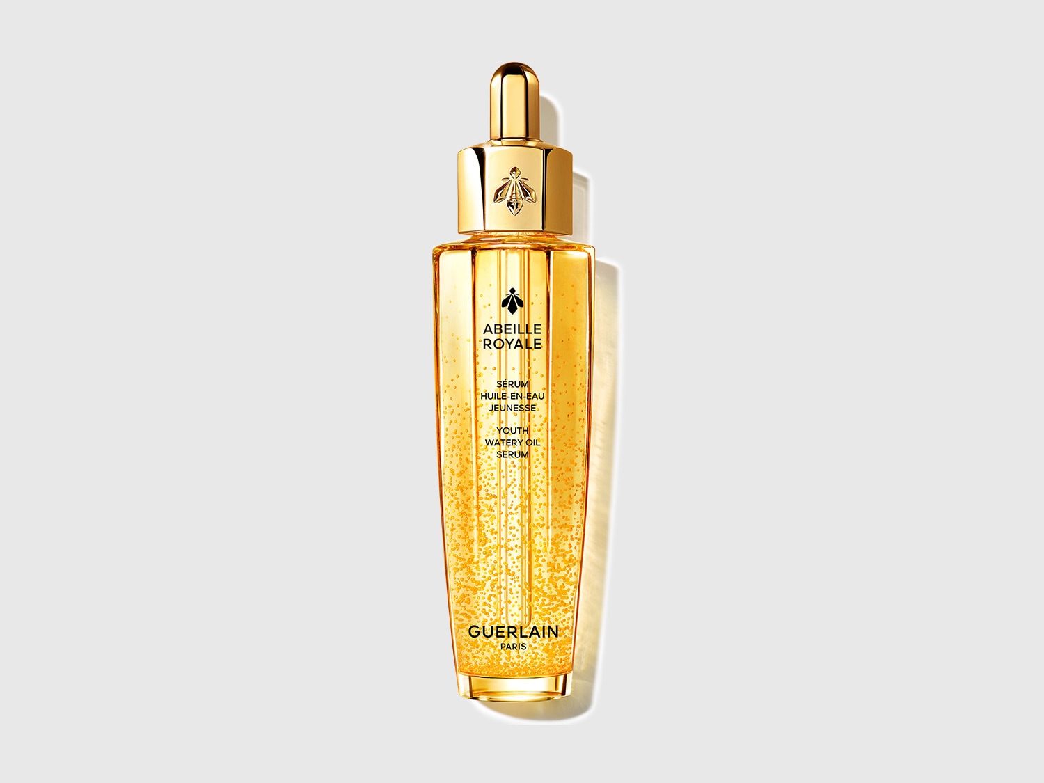 Découvrez le Sérum Abeille Royale de Guerlain, un élixir de jeunesse en huile-en-eau, présenté dans un flacon doré élégant avec un applicateur pipette.