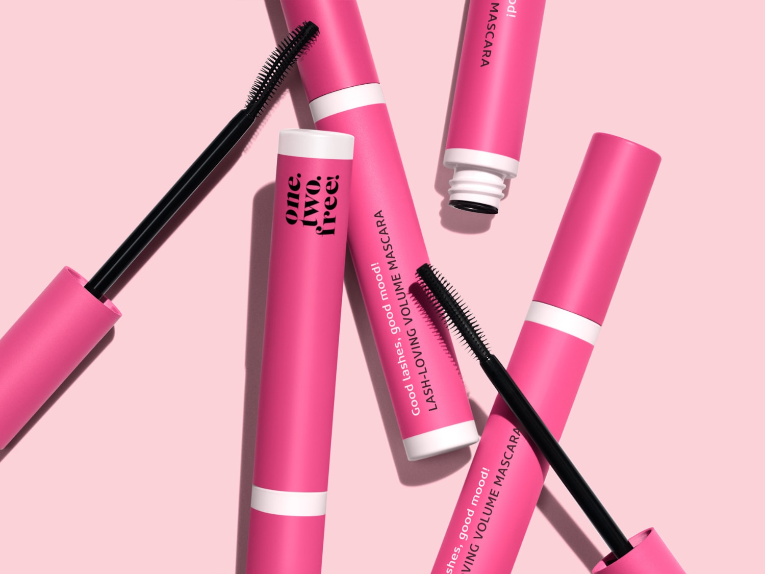 Różowe opakowania maskary do rzęs z czarną szczoteczką i napisem „Good lashes, good mood! one. two. free! LASH-LOVING VOLUME MASCARA”.
