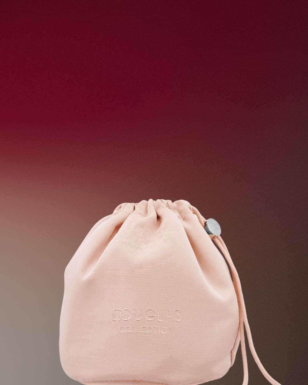 Jasnoróżowy woreczek ze sznurkiem z napisem Douglas Collection.