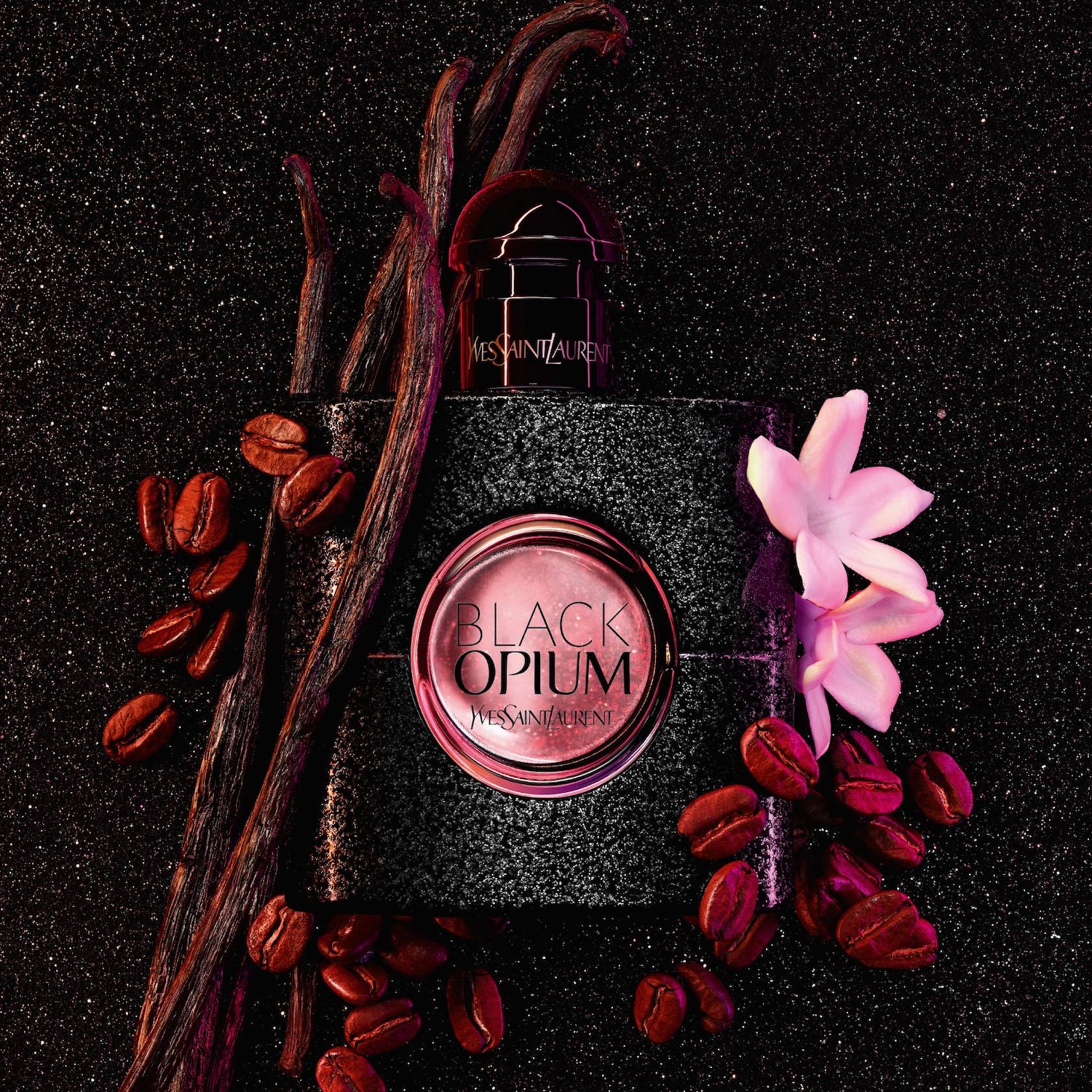 A Yves Saint Laurent Black Opium parfümöt egy virág, kávébab és vaníliarúd veszi körül, csillogó fekete háttér előtt.