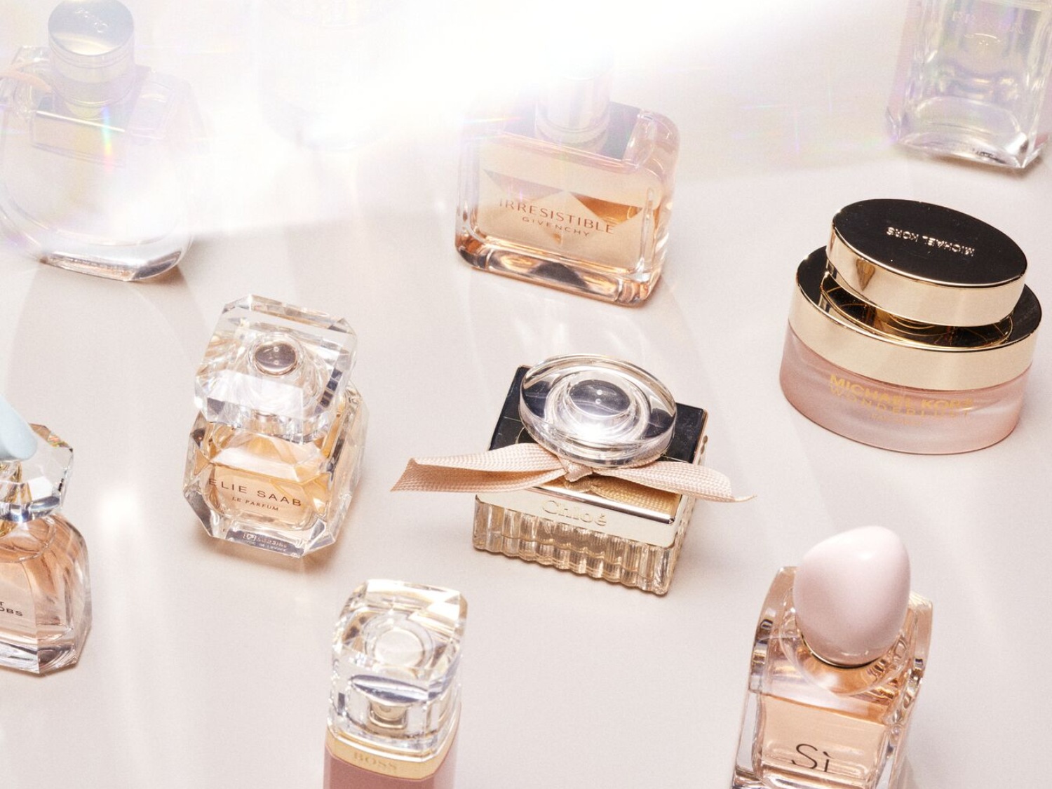 Descubre una variedad de perfumes de marcas como Chloé, Michael Kors y Elie Saab, cada uno en frascos únicos y elegantes.