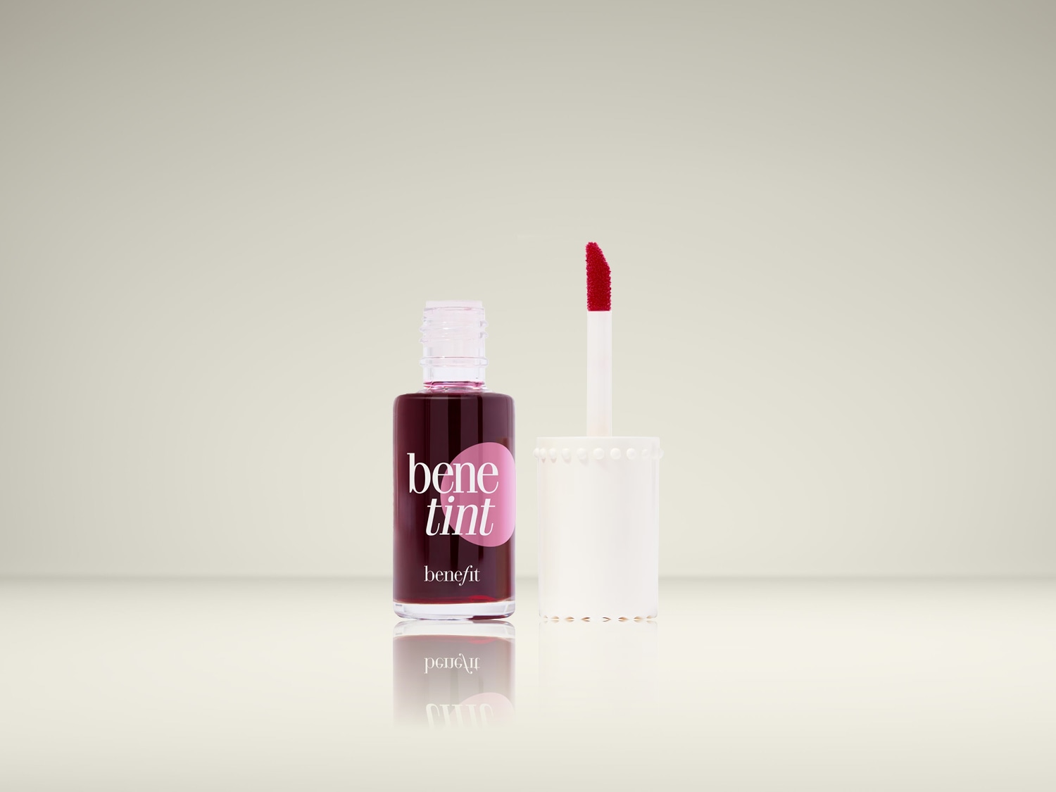 De Benefit Benetint Lip & Cheek Stain in een transparant flesje met roze etiket en een applicator met rode punt, perfect voor een natuurlijke blos.