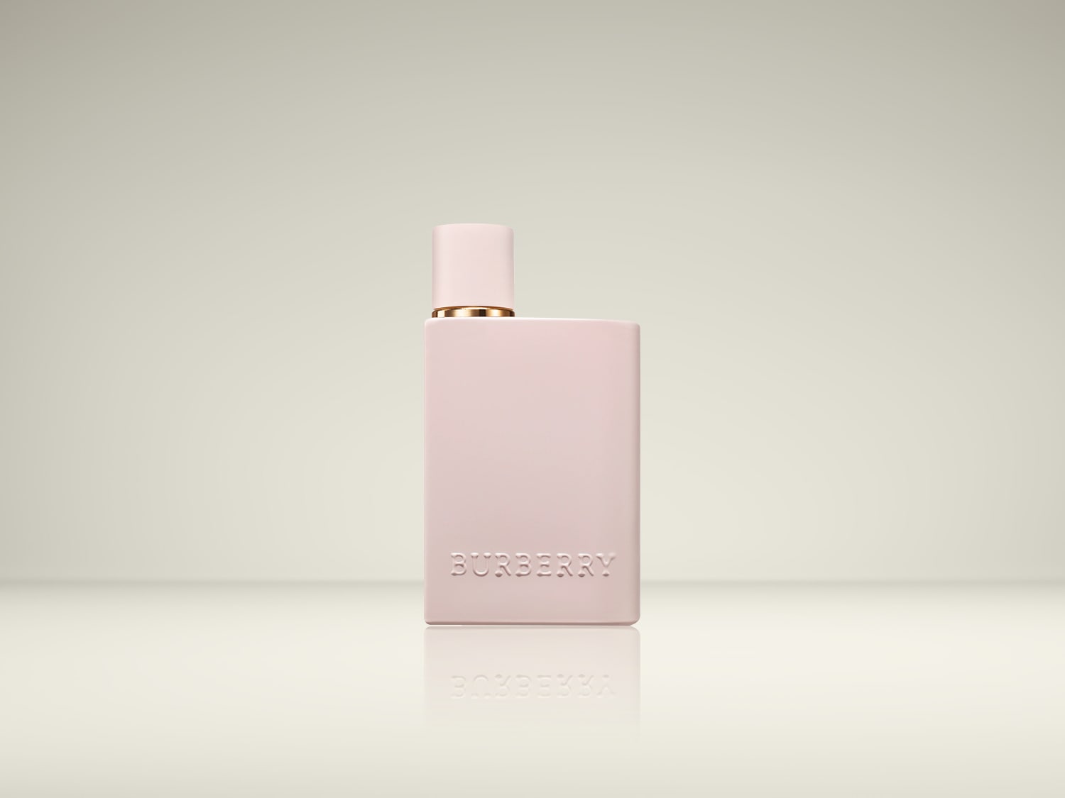 Een roze, rechthoekige Burberry parfumfles met een gouden randje onder de dop, staat op een glanzend oppervlak met de merknaam in reliëf op de voorkant.