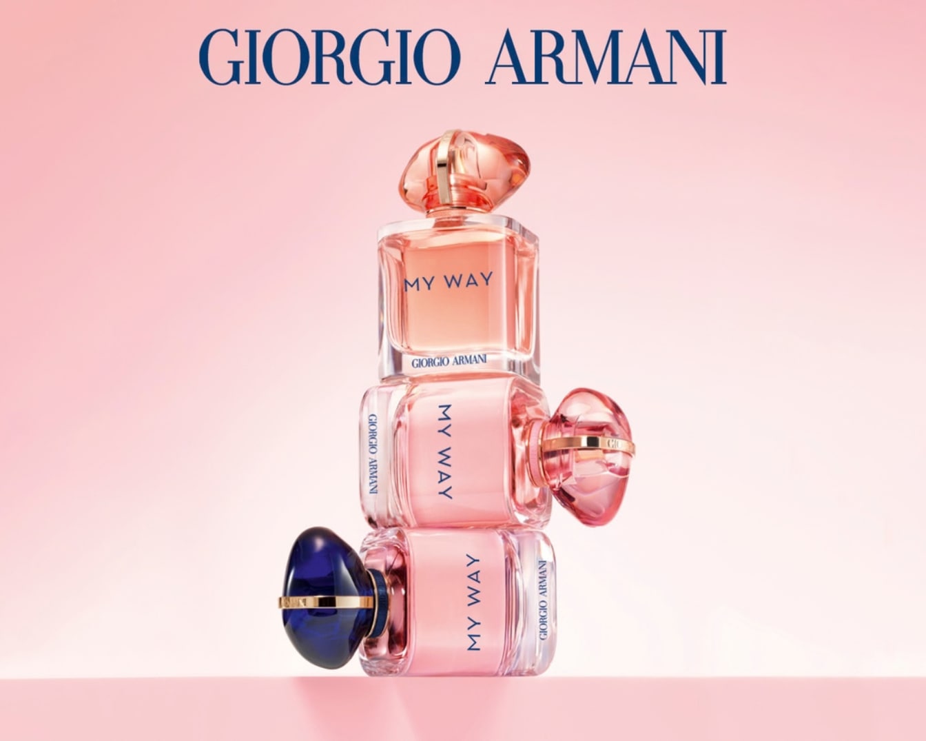 A Giorgio Armani My Way parfümök elegáns, rózsaszín árnyalatú üvegcséi egymásra halmozva, a márka nevével a háttérben, rózsaszín alapon.