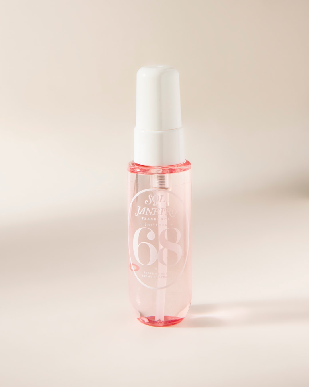 Le parfum Sol de Janeiro Cheirosa 68 est présenté dans un flacon vaporisateur transparent avec un liquide rose pâle et un capuchon blanc, idéal pour une brume parfumée rafraîchissante.