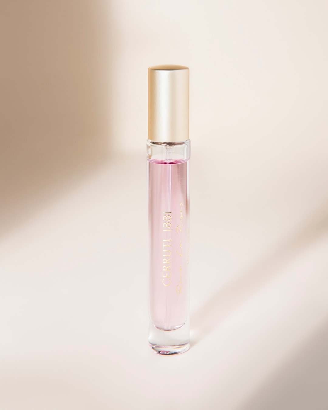 Le parfum Cerruti 1881 Rêve de Roses est présenté dans un flacon en verre transparent avec un liquide rose pâle et un capuchon doré, évoquant une élégance délicate.