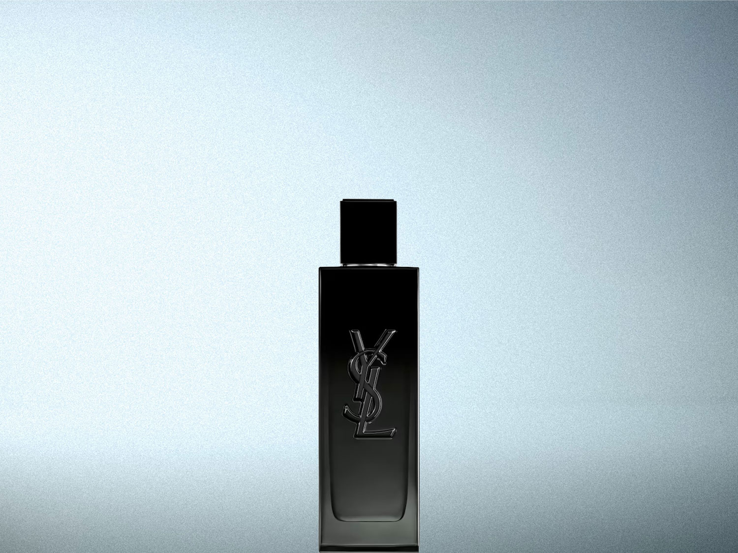 Le parfum YSL pour homme est présenté dans un flacon rectangulaire noir avec le logo YSL en relief sur le devant, sur un fond gris clair.