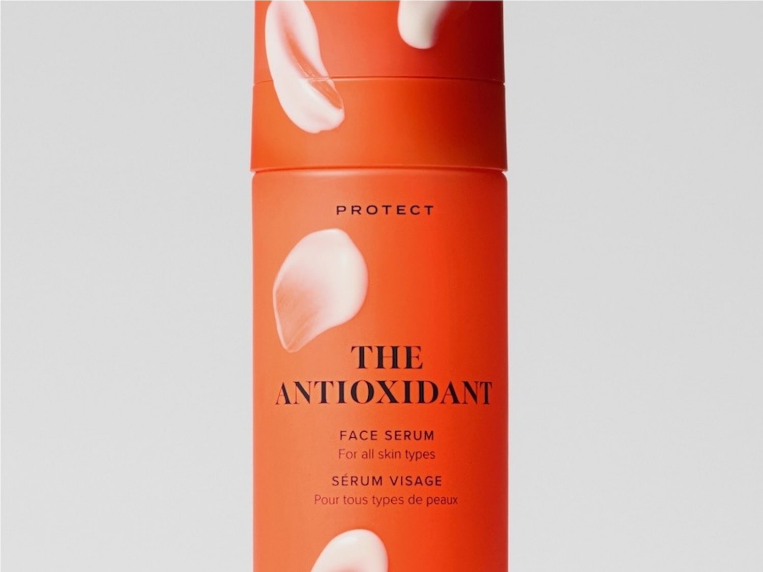 The Antioxidant Face Serum in a vibrant orange bottle with white cream swirls, designed to protect and nourish all skin types.