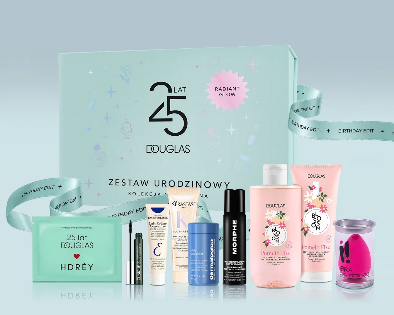 Zestaw urodzinowy Douglas „Radiant Glow” to eleganckie pudełko w kolorze miętowym z napisem „25 lat Douglas” i różową gwiazdką z napisem „Radiant Glow”, przewiązane wstążką z napisem „Birthday Edit”.