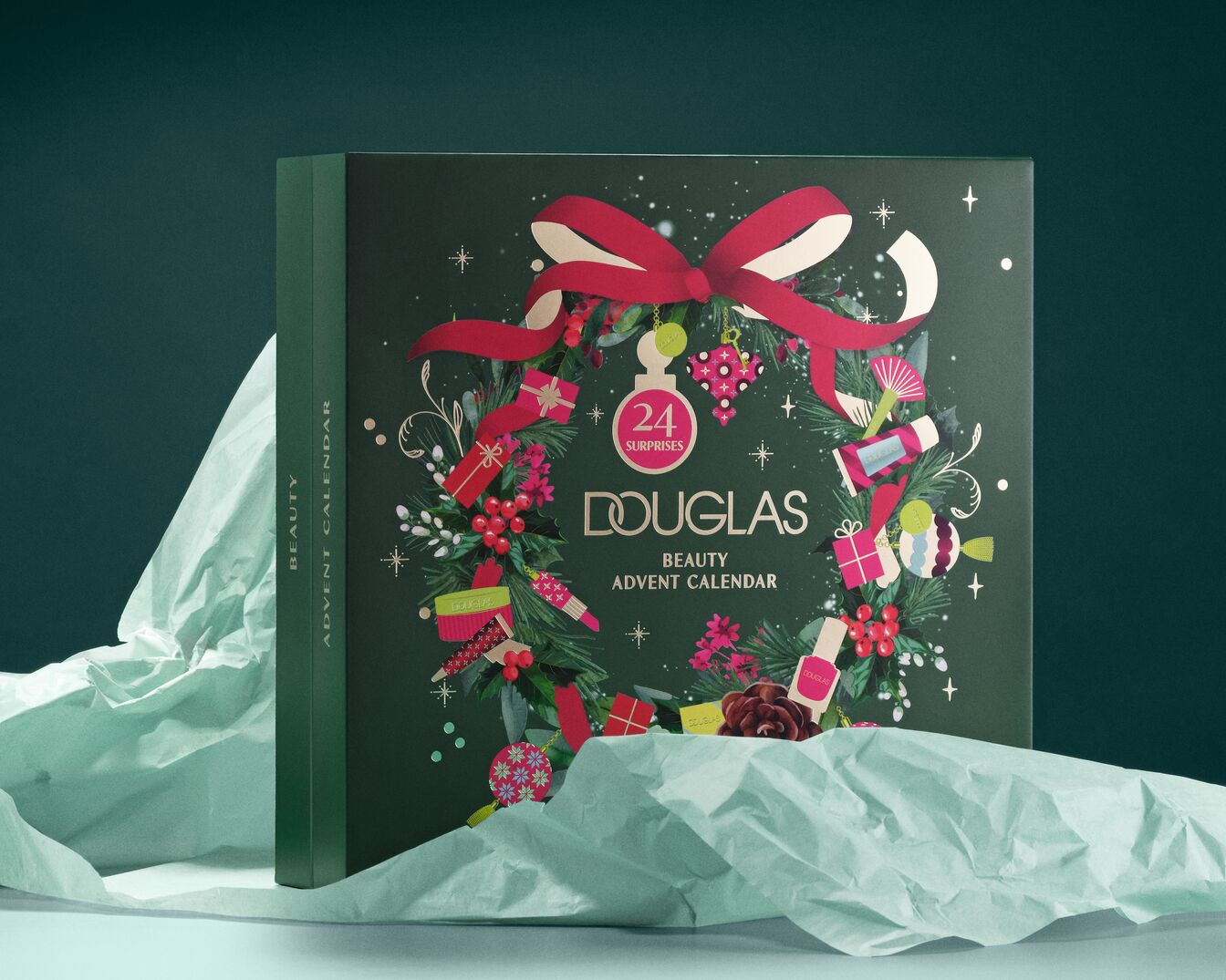 Il calendario dell'Avvento Douglas Beauty, di colore verde scuro, è decorato con un nastro rosso, bacche e regali, e promette 24 sorprese di bellezza.