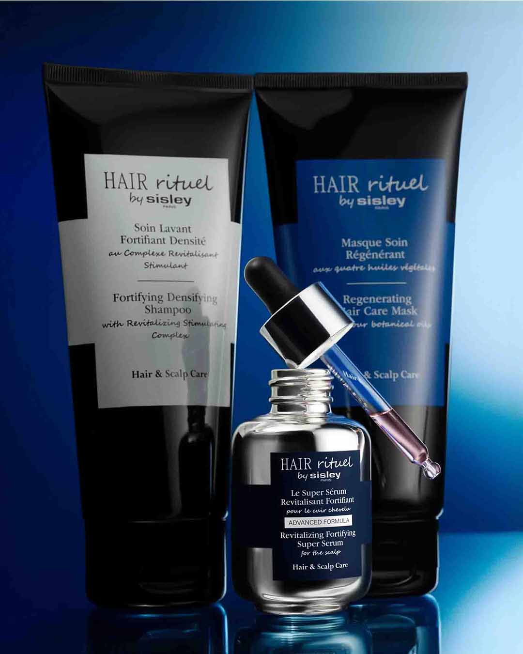 Découvrez la gamme Hair Rituel by Sisley, avec le shampoing fortifiant densifiant, le masque de soin régénérant et le super sérum revitalisant fortifiant pour le cuir chevelu, présentés dans des emballages élégants noirs et argentés.