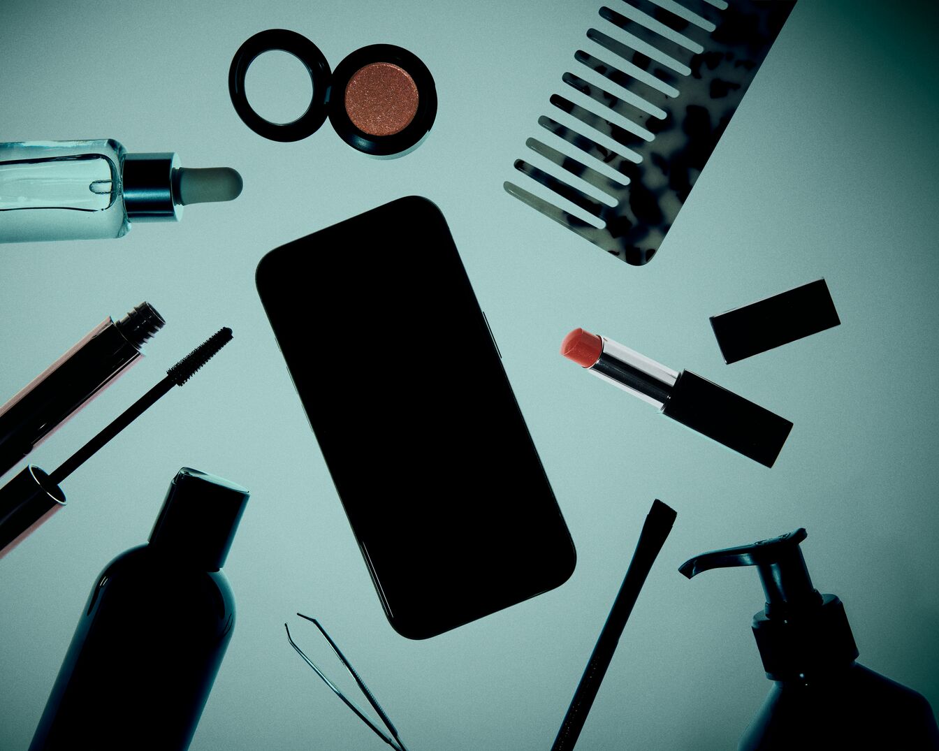 Na jasnoniebieskim tle leżą kosmetyki i telefon komórkowy, w tym butelka z zakraplaczem, tusz do rzęs, cień do powiek, szminka, grzebień, pęseta i butelka z pompką.
