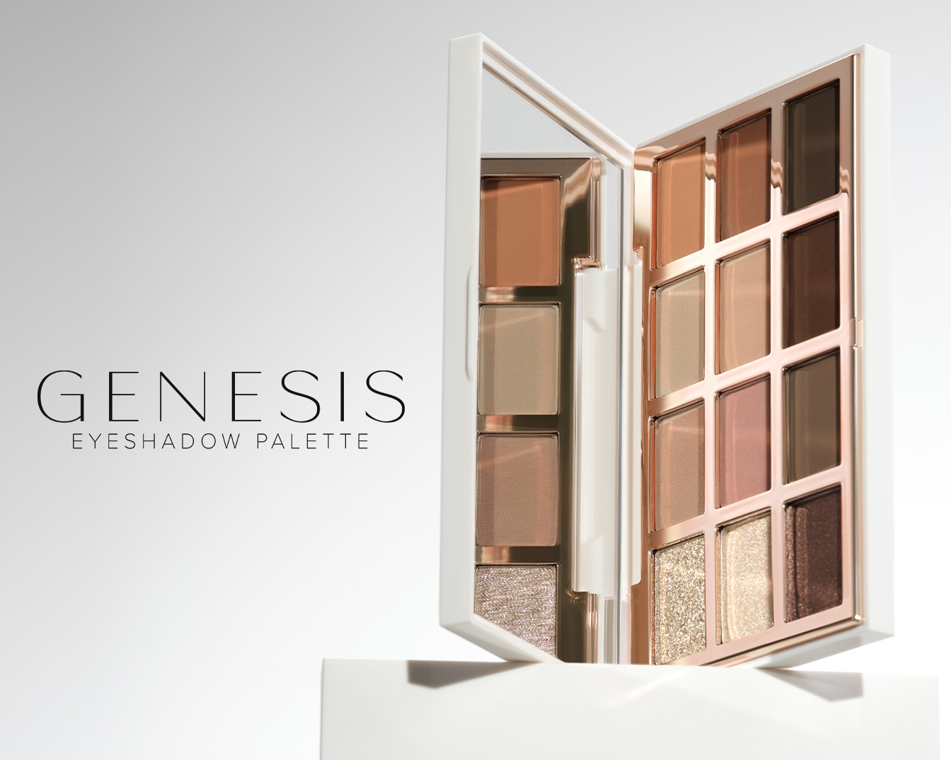 Die Genesis Lidschattenpalette präsentiert sich in einem weißen Etui mit einem Spiegel im Deckel und zwölf Lidschatten in verschiedenen Braun-, Gold- und Rosatönen, darunter matte und schimmernde Shades.