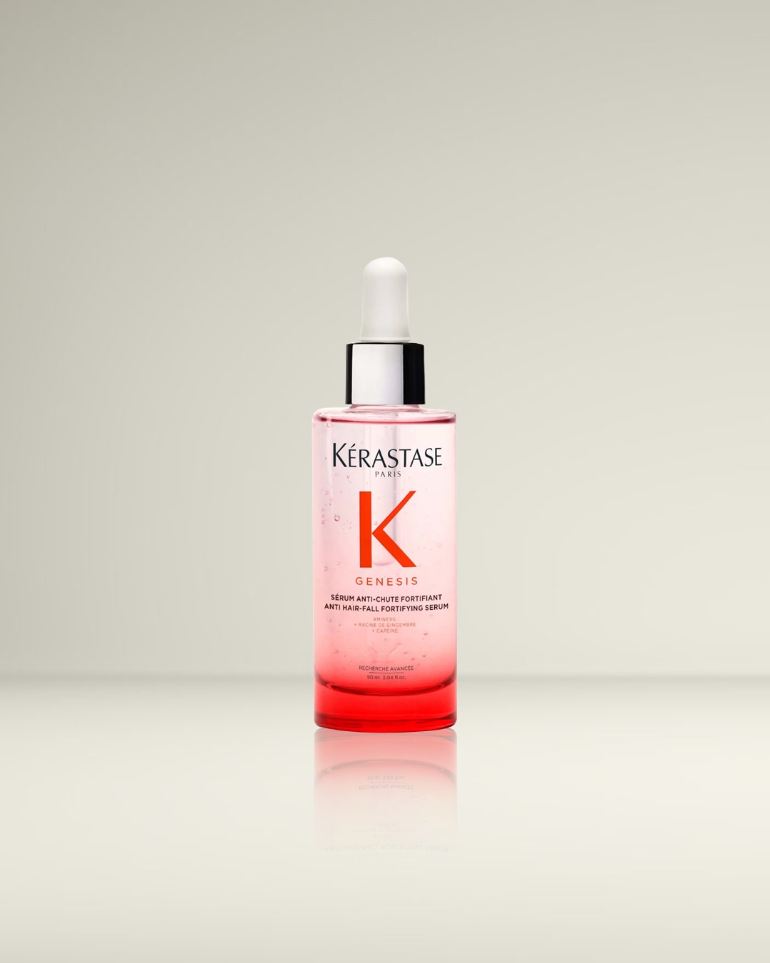 Kérastase Genesis Anti Hair-Fall Fortifying Serum in een transparante fles met roze vloeistof en een witte druppelaar, ontworpen om haaruitval te verminderen en het haar te versterken.