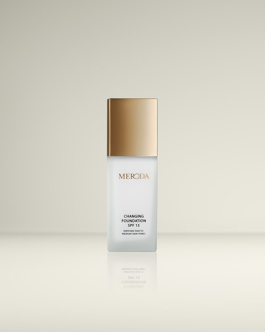 De Meroda Changing Foundation SPF 15 in een matte glazen fles met een goudkleurige dop, perfect voor lichte tot medium huidtinten.