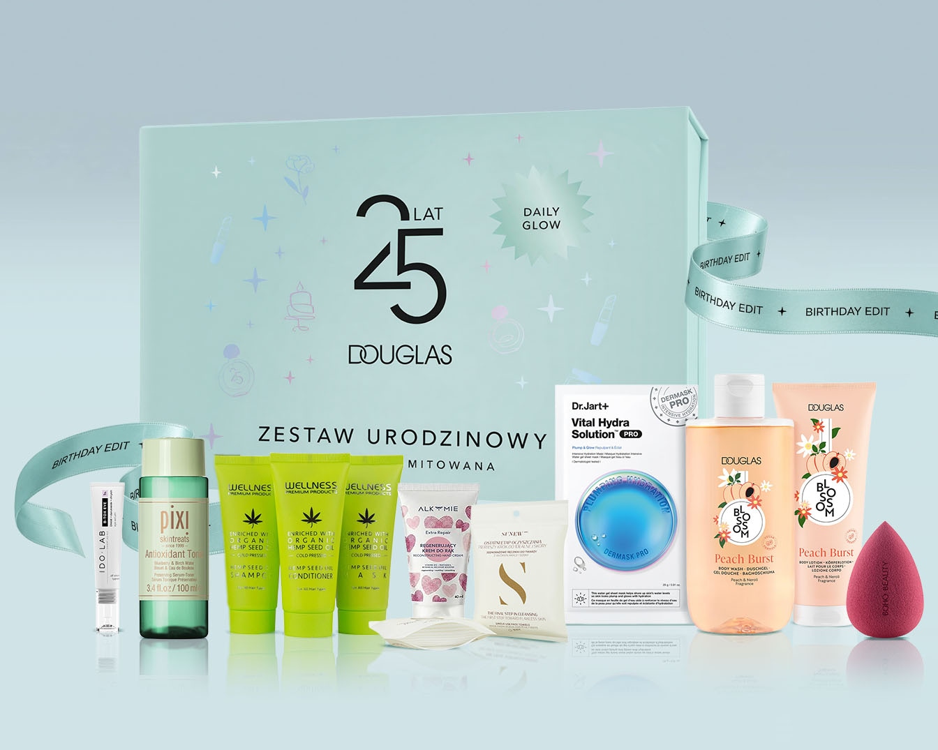 Zestaw urodzinowy Douglas "Daily Glow" na 25-lecie, zawiera różnorodne kosmetyki do pielęgnacji twarzy i ciała, w tym produkty do makijażu, szampony, odżywki, kremy i balsamy, wszystko zapakowane w eleganckie pudełko prezentowe.