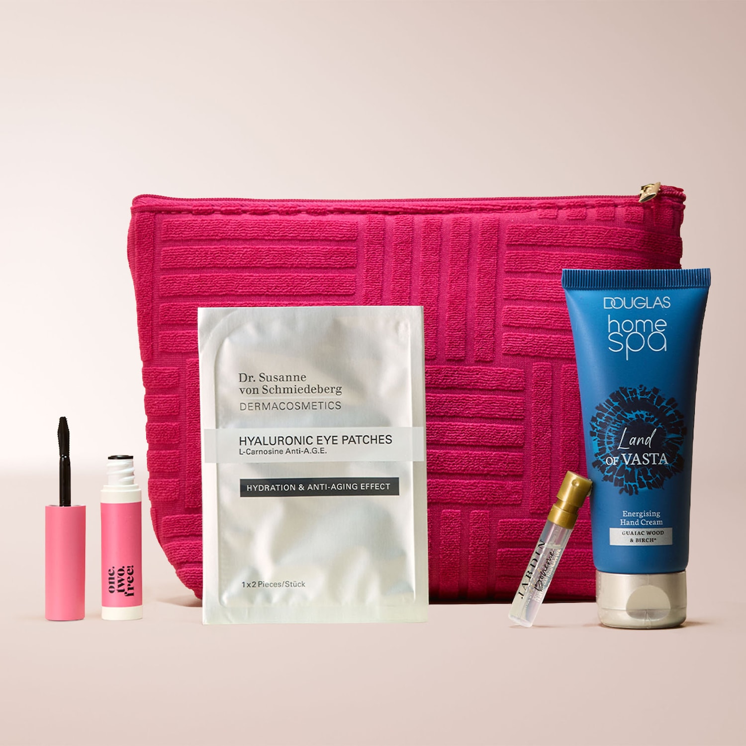 Ein leuchtend pinkes, rechteckiges Kosmetiketui mit Reißverschluss, gefüllt mit einer Auswahl an Schönheitsprodukten, darunter eine Mascara, Augenpads, eine Handcreme und ein Parfümzerstäuber.