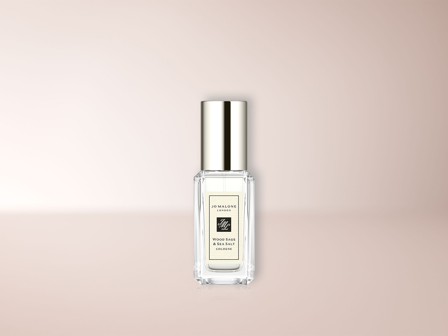 Das Jo Malone London Wood Sage & Sea Salt Cologne ist in einem eleganten, rechteckigen Glasflakon mit silbernem Sprühkopf und Deckel erhältlich, der auf einem hellrosa Hintergrund steht.