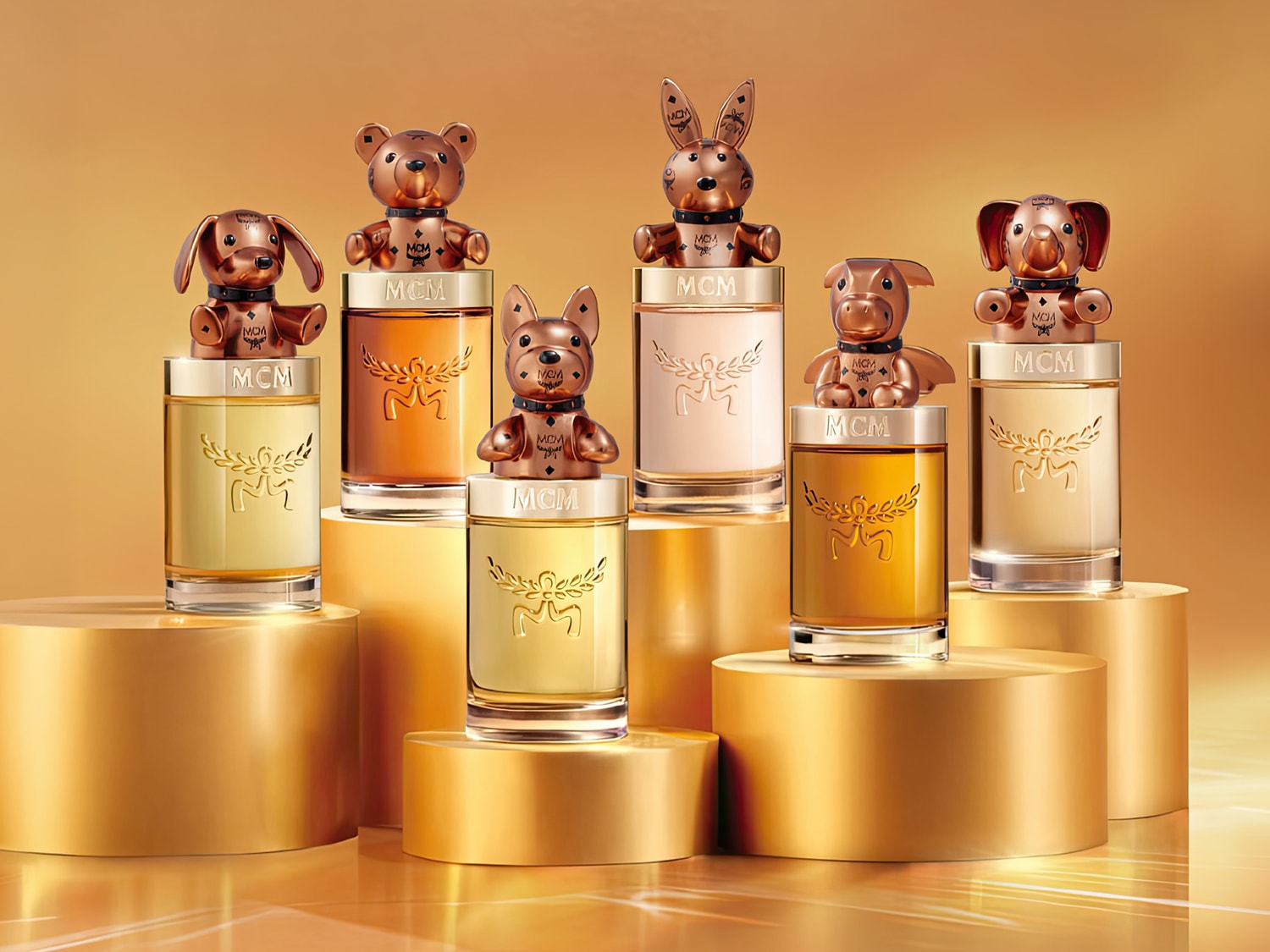 Sechs MCM-Parfümflaschen, verziert mit goldenen Tierfiguren wie einem Hund, einem Teddybären, einem Hasen, einem Schwein und einem Elefanten, stehen auf goldenen Podesten vor einem warmen, goldenen Hintergrund.