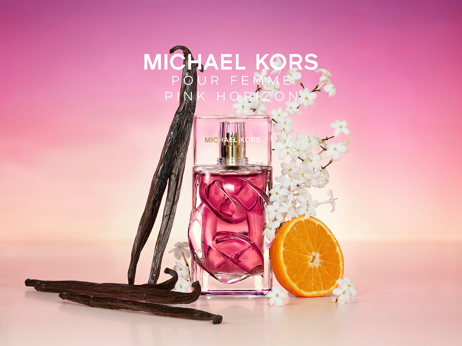 Le parfum Michael Kors Pour Femme Pink Horizon est présenté dans un flacon en verre transparent avec un liquide rose vif, entouré de gousses de vanille, de fleurs blanches et d'une demi-orange, sur un fond dégradé de rose et d'orange.