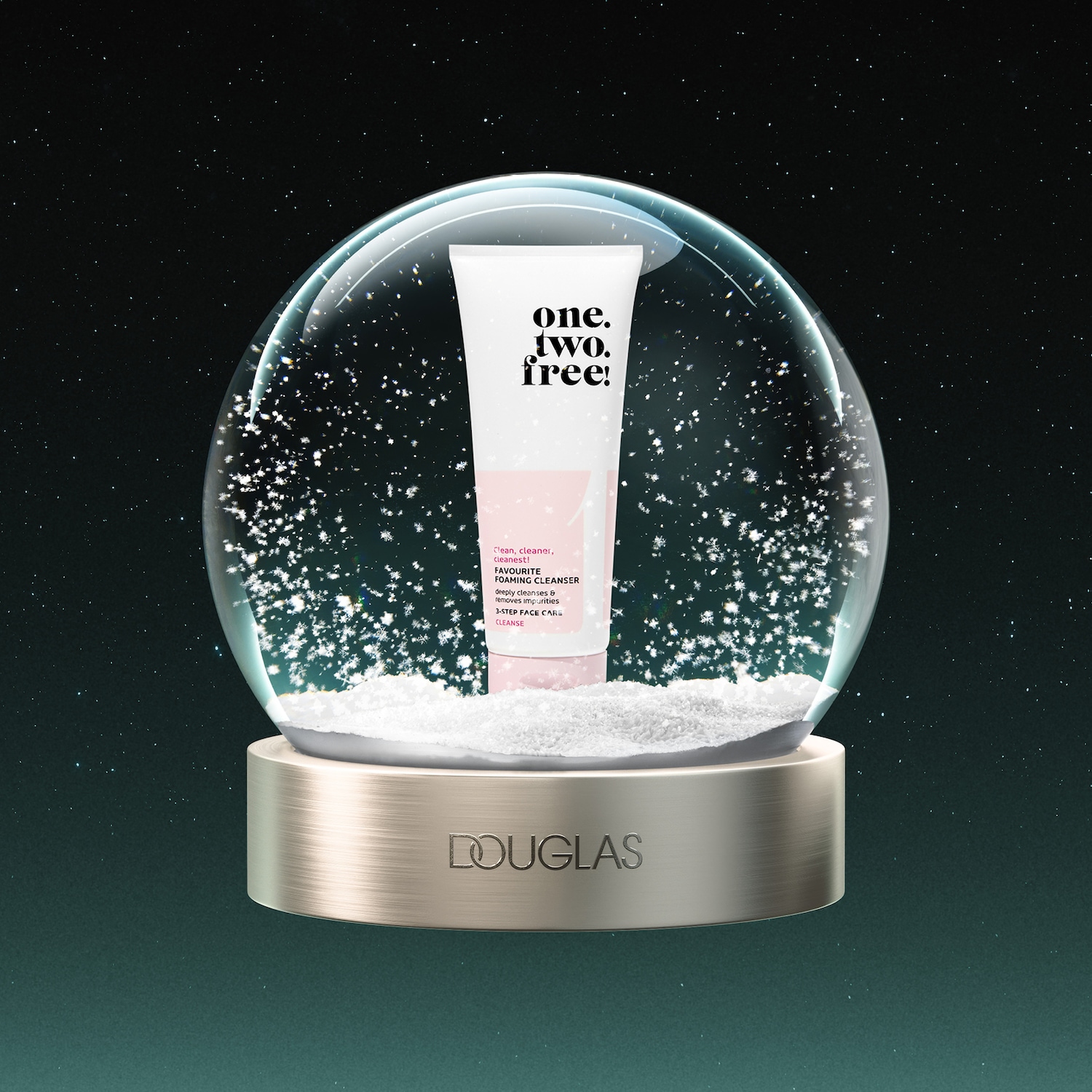 De one.two.free! FAVOURITE FOAMING CLEANSER, een witte tube met roze accenten, staat in een sneeuwbol met de tekst "DOUGLAS" op de gouden voet, tegen een donkergroene sterrenhemel.