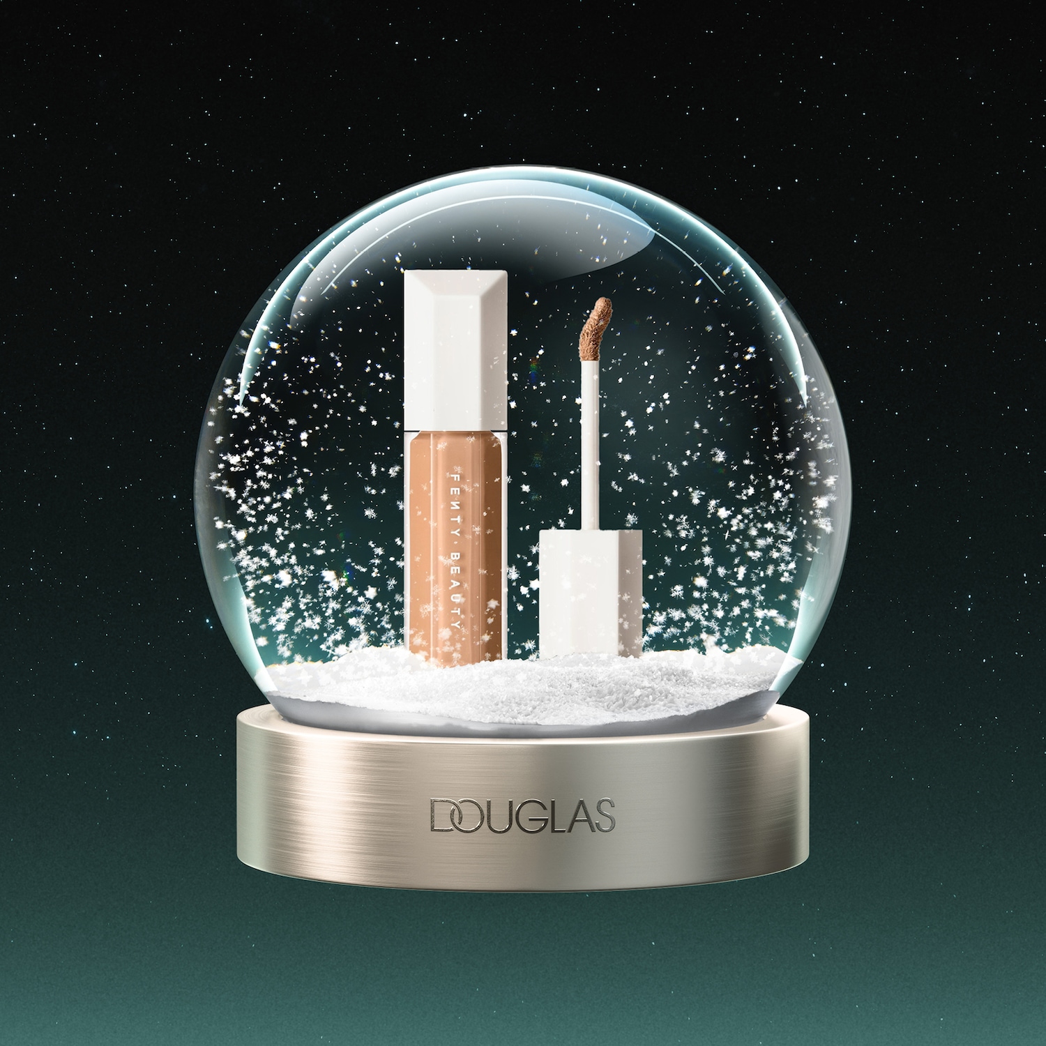 Een Fenty Beauty concealer en applicator zijn te zien in een sneeuwbol met de tekst "DOUGLAS" op de gouden basis, tegen een donkergroene, sterrenhemelachtergrond.
