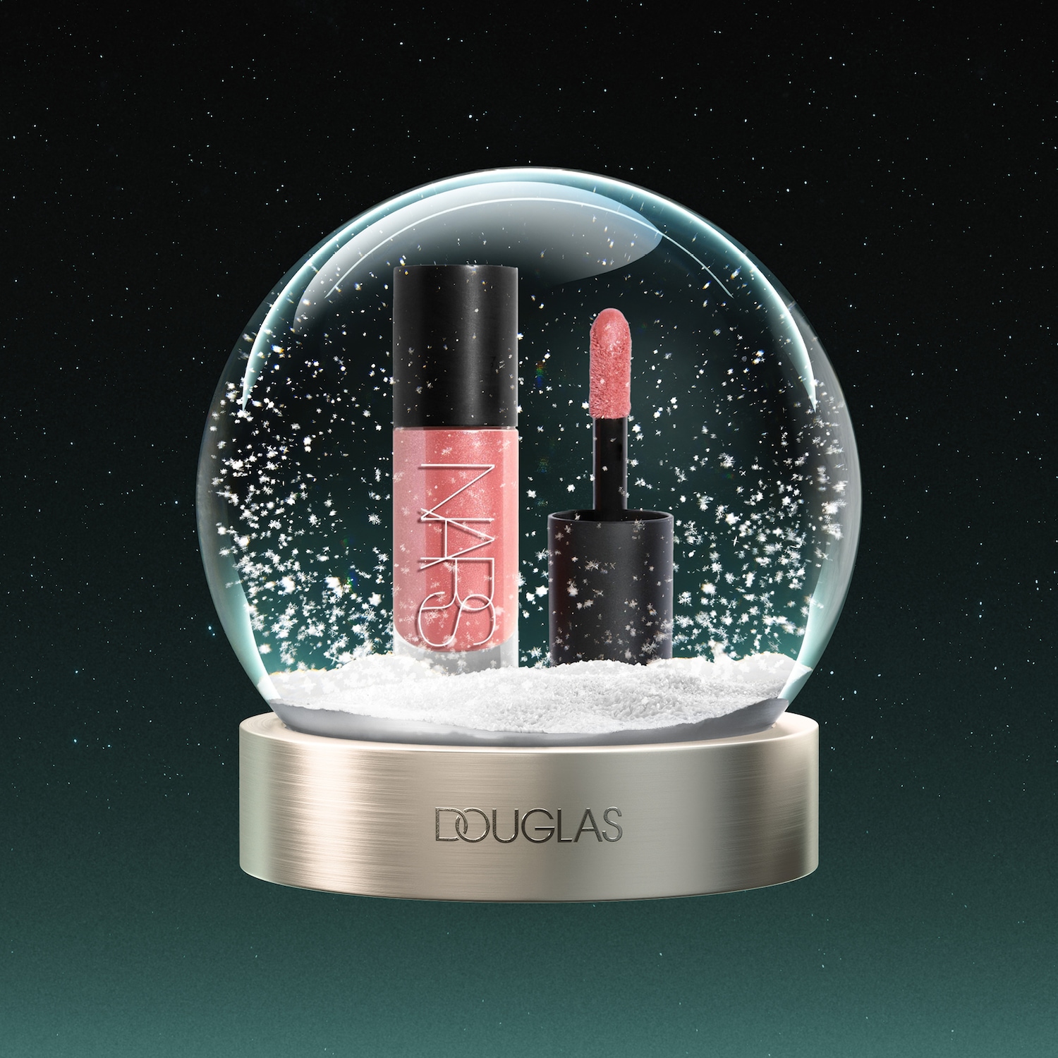 Een NARS lipgloss in een glazen sneeuwbol met vallende sneeuwvlokken, staand op een gouden voetstuk met het Douglas-logo, tegen een donkergroene sterrenhemel.